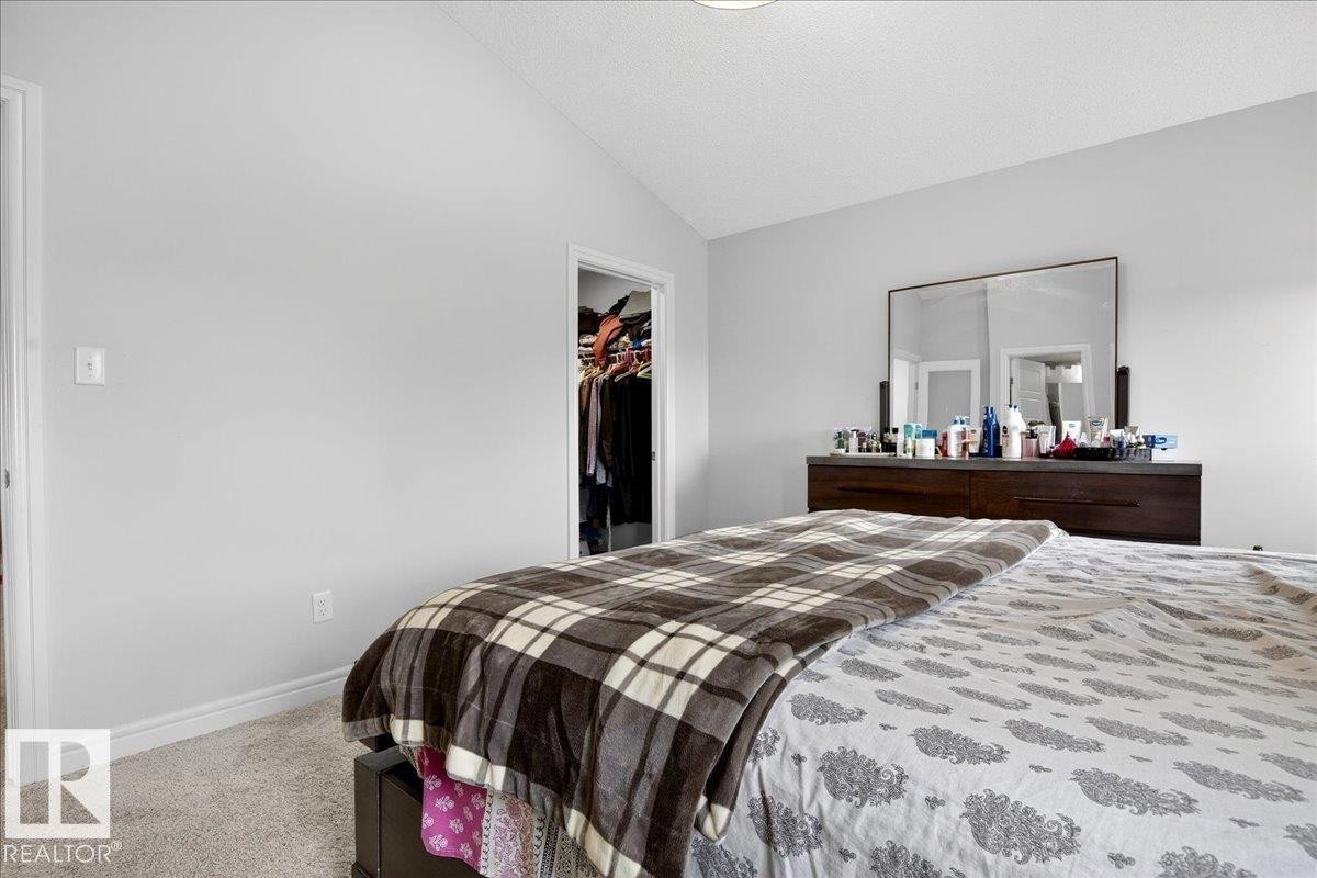Bedroom featuring light grey walls, a vaulted ceiling, and carpeted flooring - 203 Cavanagh Common, Edmonton, AB - Indoor Photo Showing Bedroom