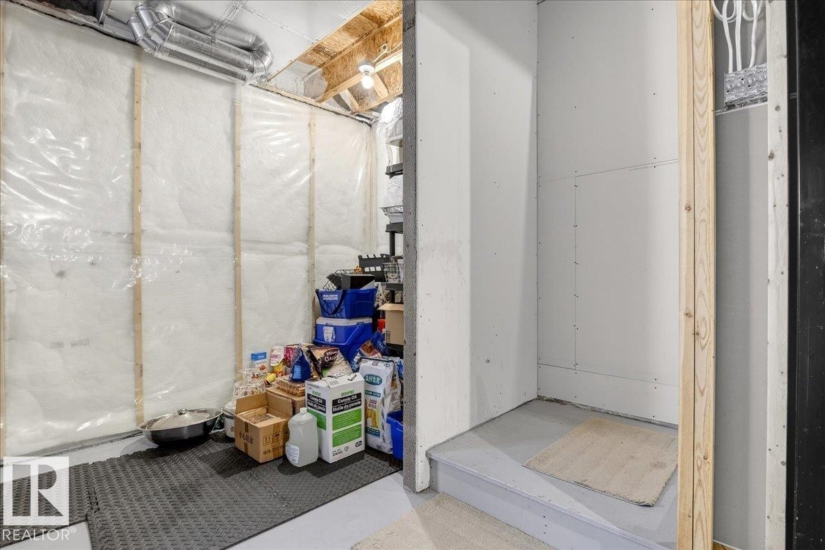 The property features an unfinished basement area with visible insulation, exposed wooden framing, and overhead ductwork - 203 Cavanagh Common, Edmonton, AB - Indoor