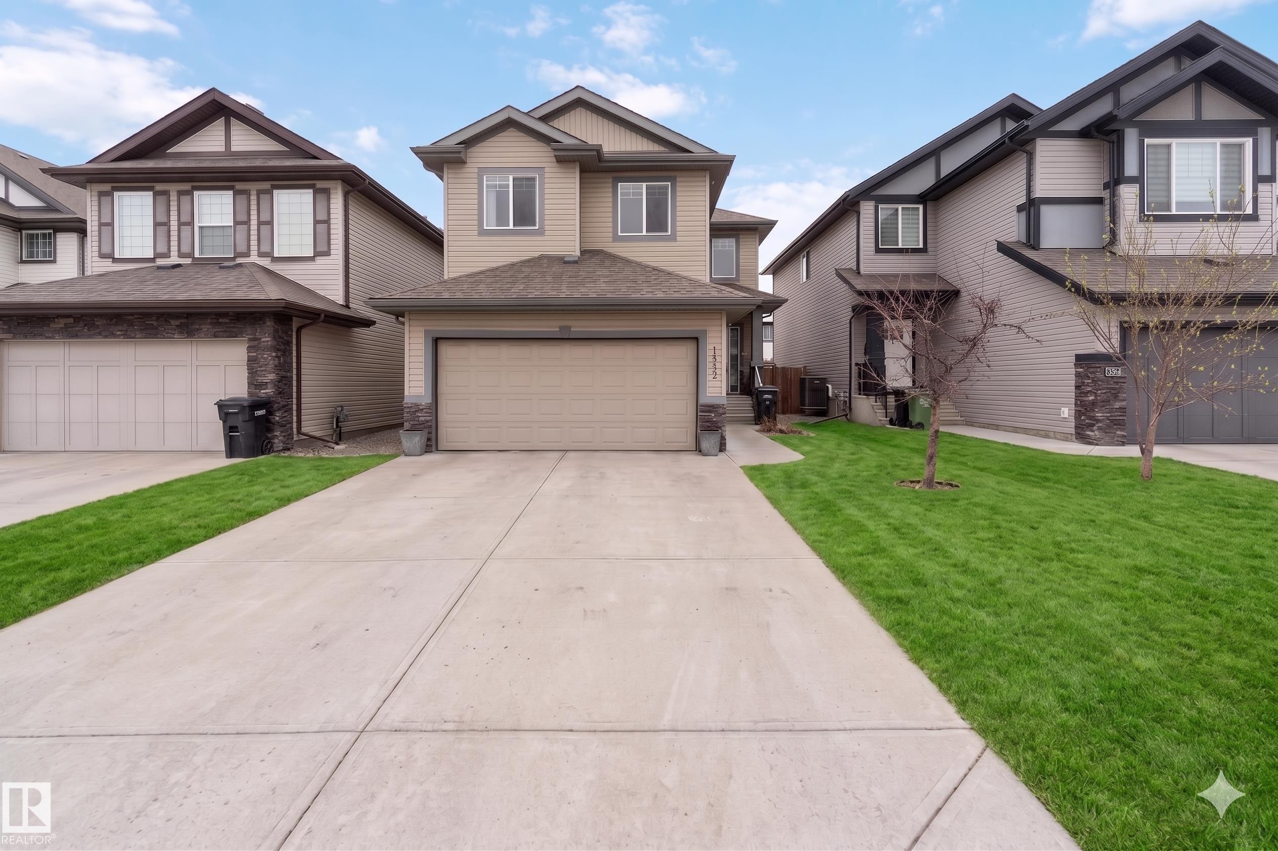 Two-story residence featuring a neutral-toned siding exterior with stone veneer accents - 12232 167B Avenue, Edmonton, AB - Outdoor With Facade