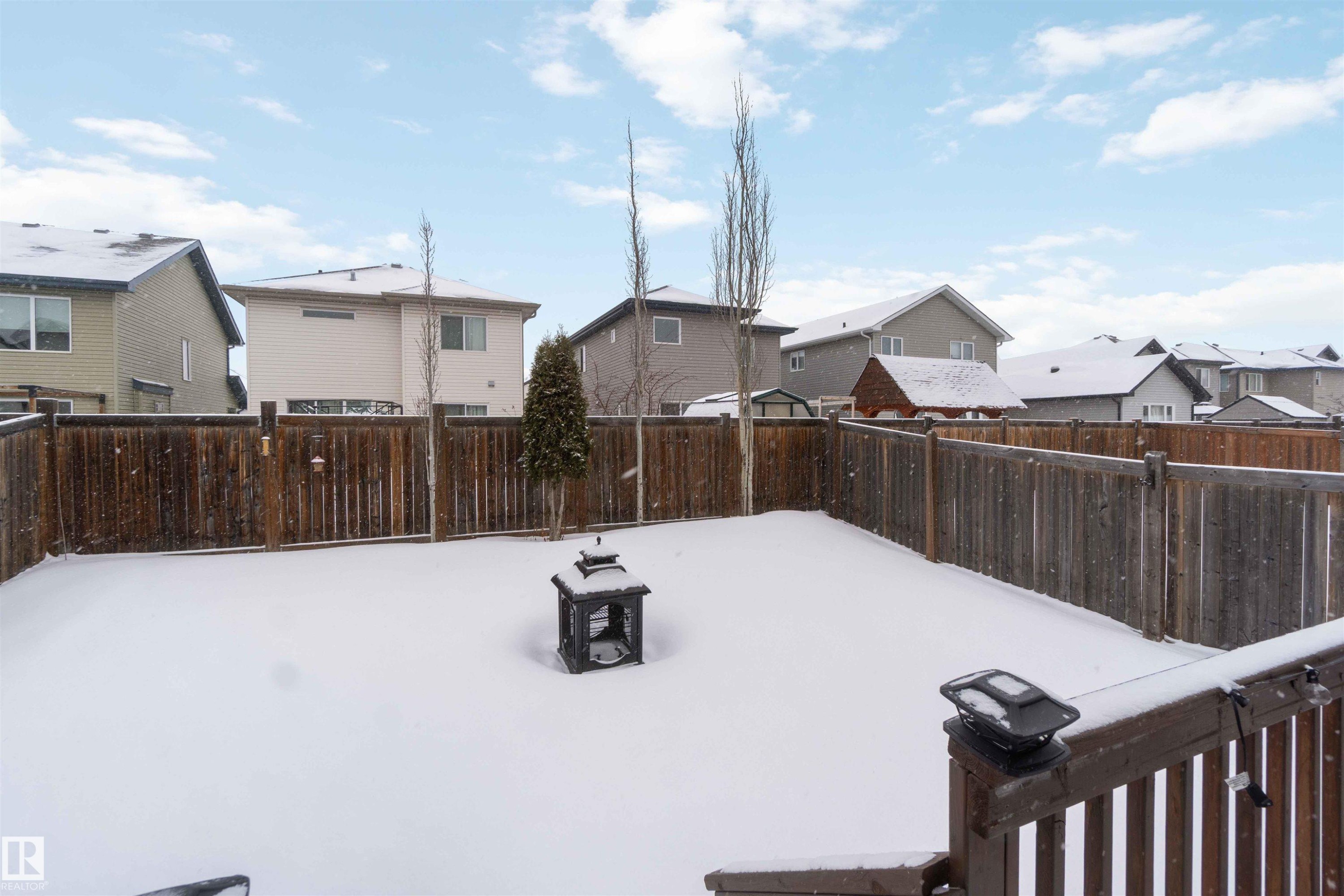 The property features a fenced yard, covered in snow, with a decorative lantern - 12232 167B Avenue, Edmonton, AB - Outdoor