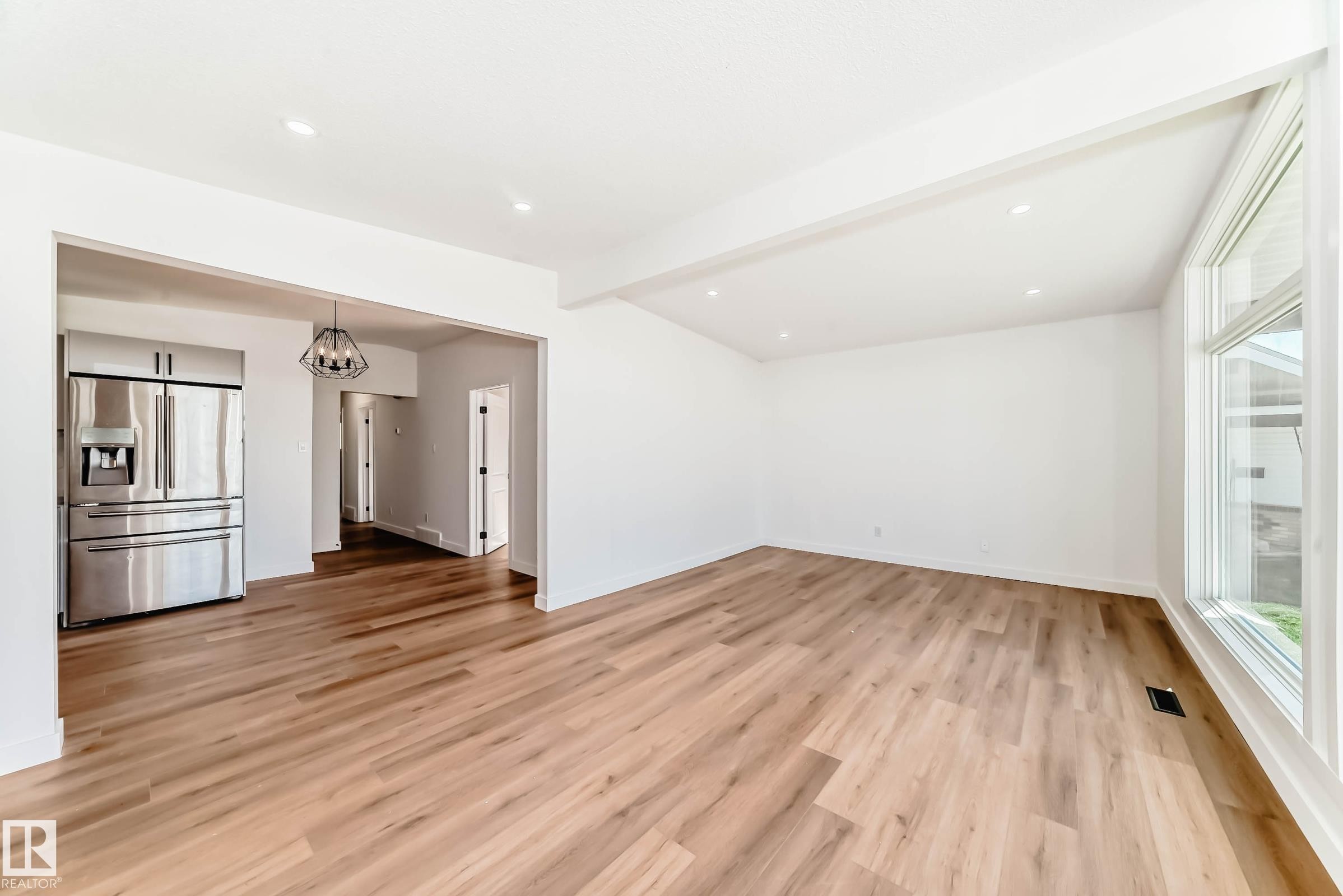 Open concept living space featuring wide plank flooring, recessed lighting, and large windows providing natural light - 7220 152A Ave, Edmonton, AB - Indoor Photo Showing Other Room