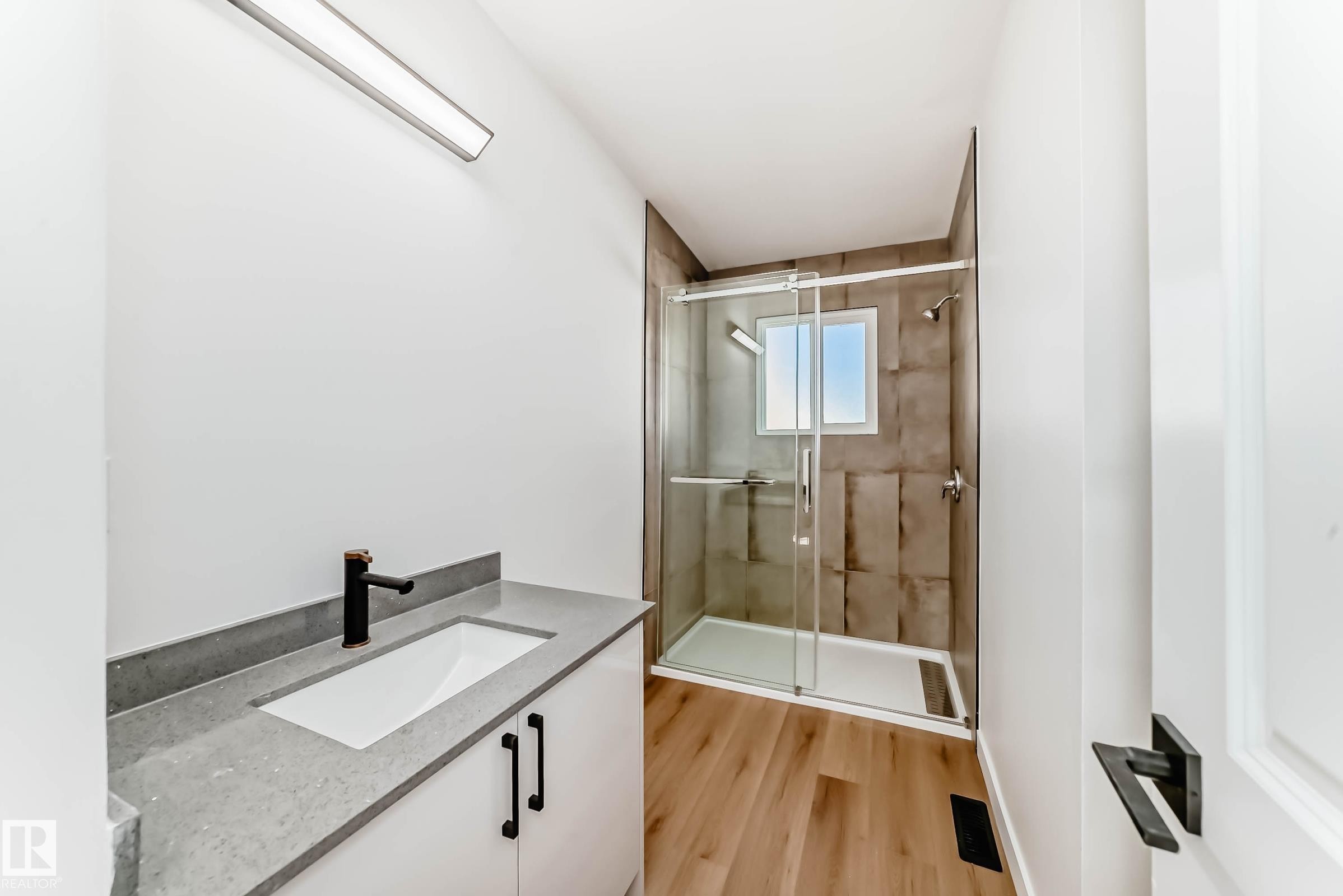 Bathroom featuring a white vanity with a rectangular sink, a grey countertop, and a black faucet - 7220 152A Ave, Edmonton, AB - Indoor