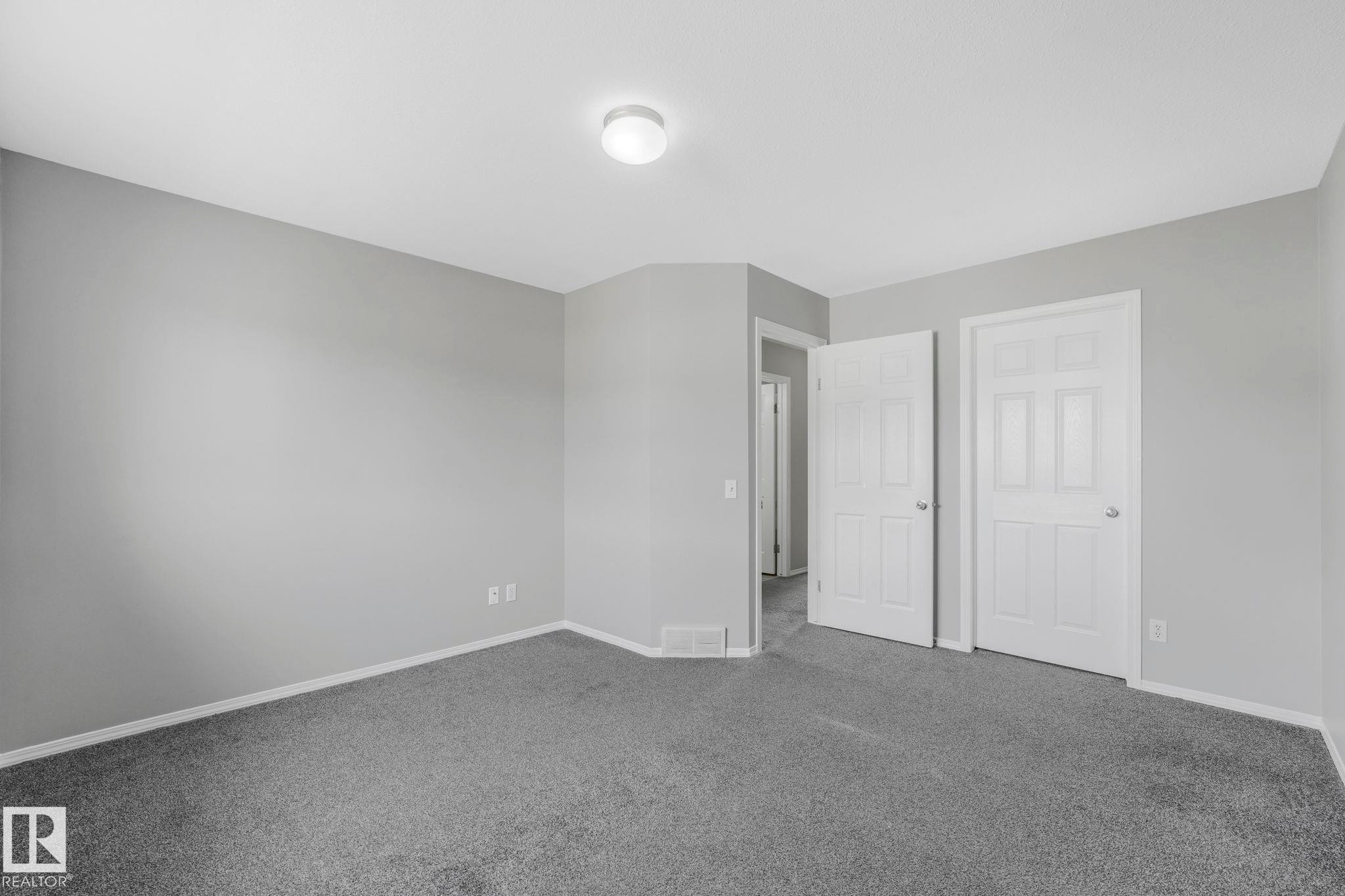 This room features neutral gray walls, gray carpeting, and a ceiling light fixture - 123 230 Edwards Drive, Edmonton, AB - Indoor Photo Showing Other Room