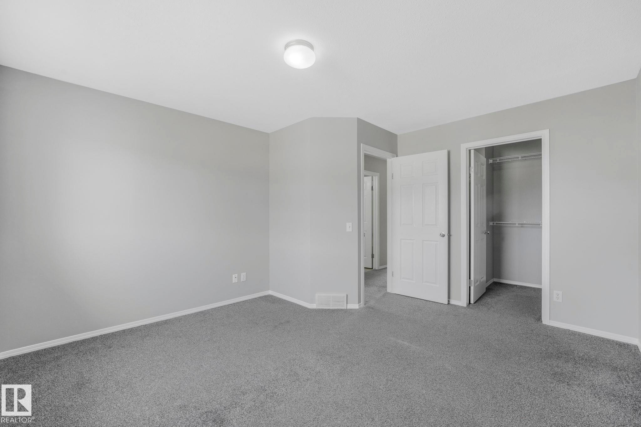 This room features light grey walls, grey carpet flooring, and a flush mount ceiling light fixture - 123 230 Edwards Drive, Edmonton, AB - Indoor Photo Showing Other Room
