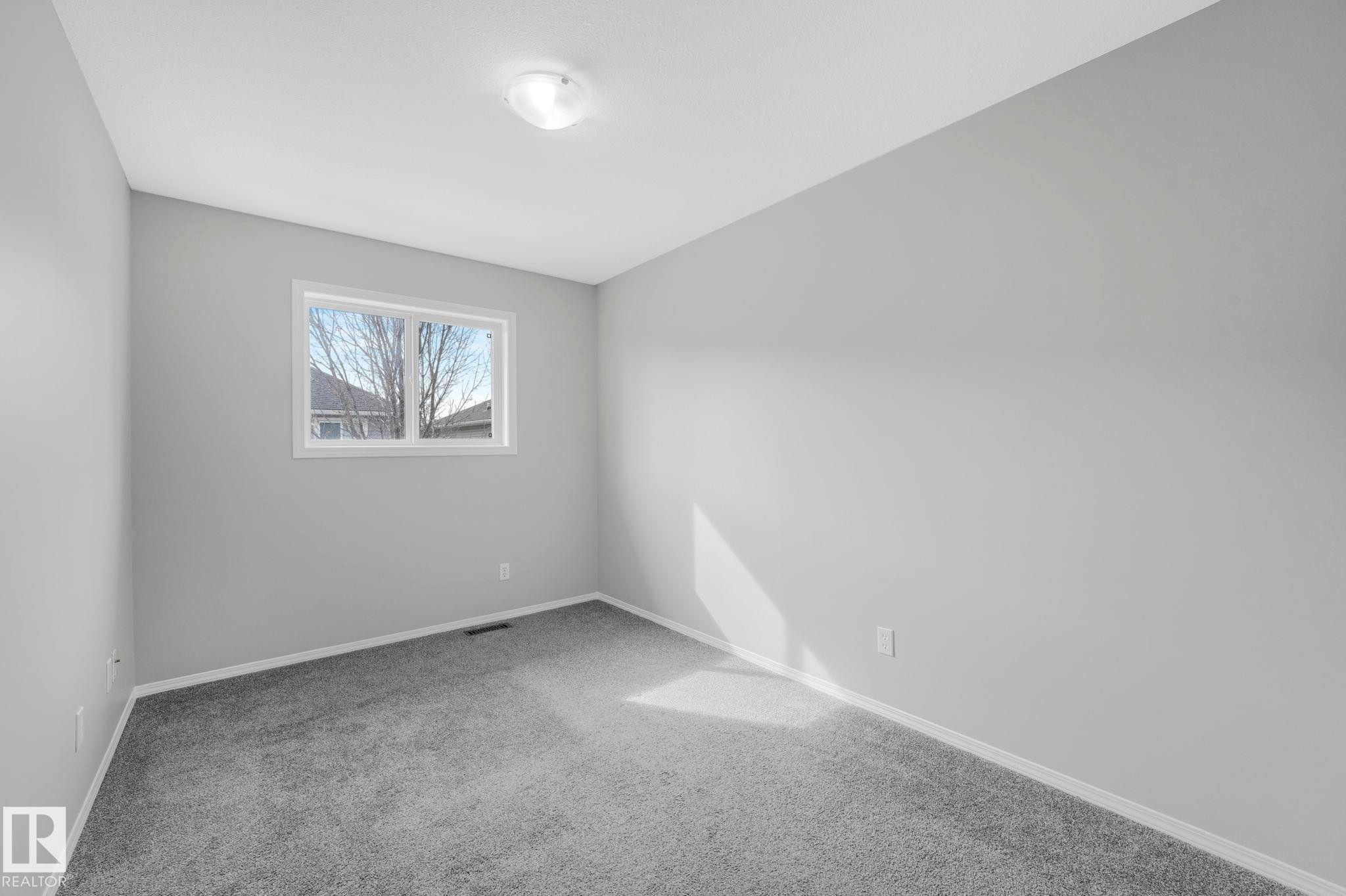 This room features light grey walls and grey carpet flooring - 123 230 Edwards Drive, Edmonton, AB - Indoor Photo Showing Other Room