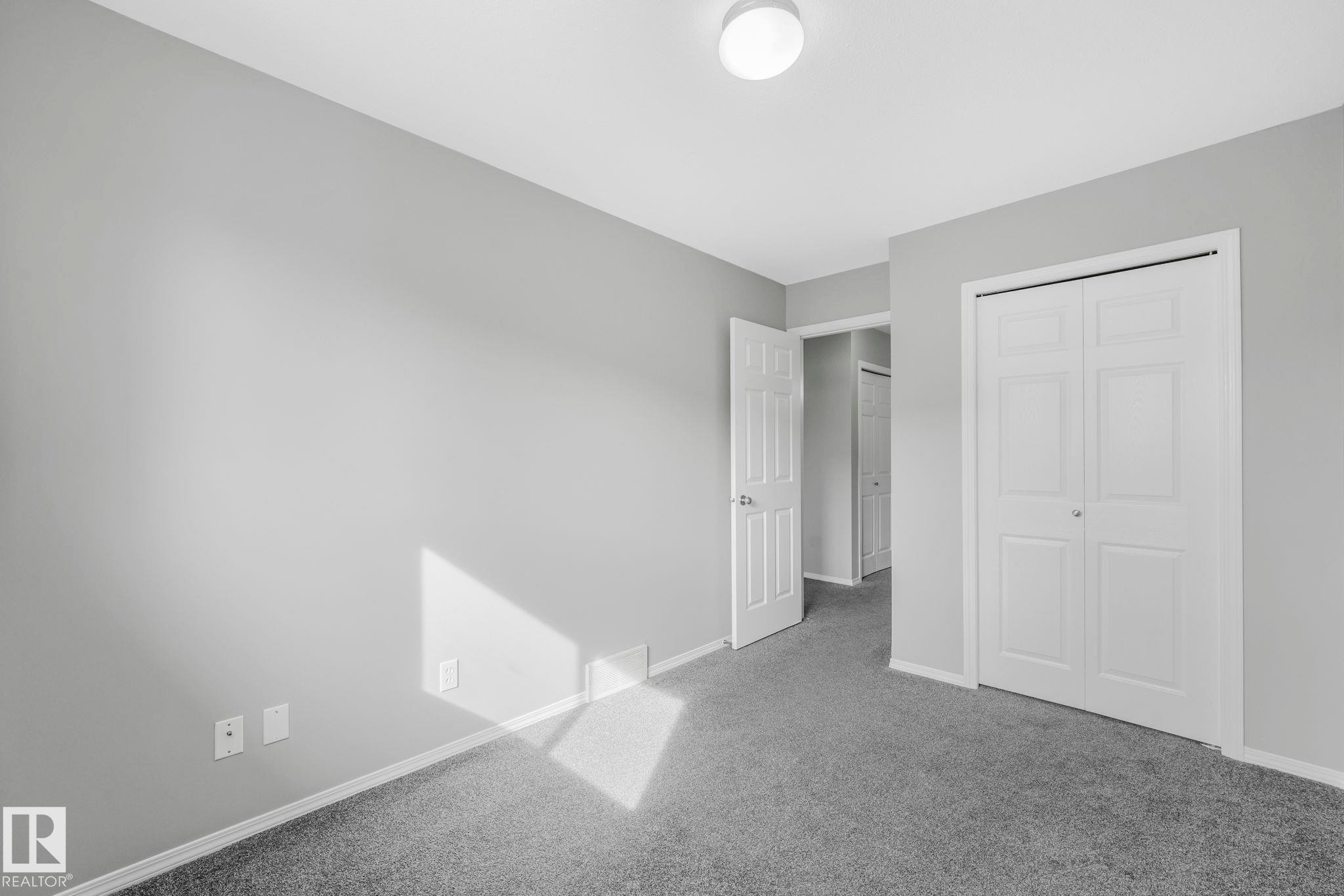 This room features grey carpeting, light grey walls, and white trim - 123 230 Edwards Drive, Edmonton, AB - Indoor