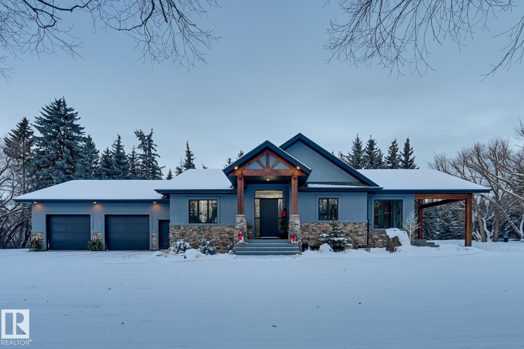 View of front facade with stone siding, an attached garage, and stucco siding - 231 75 Street, Edmonton, AB - Outdoor With Facade