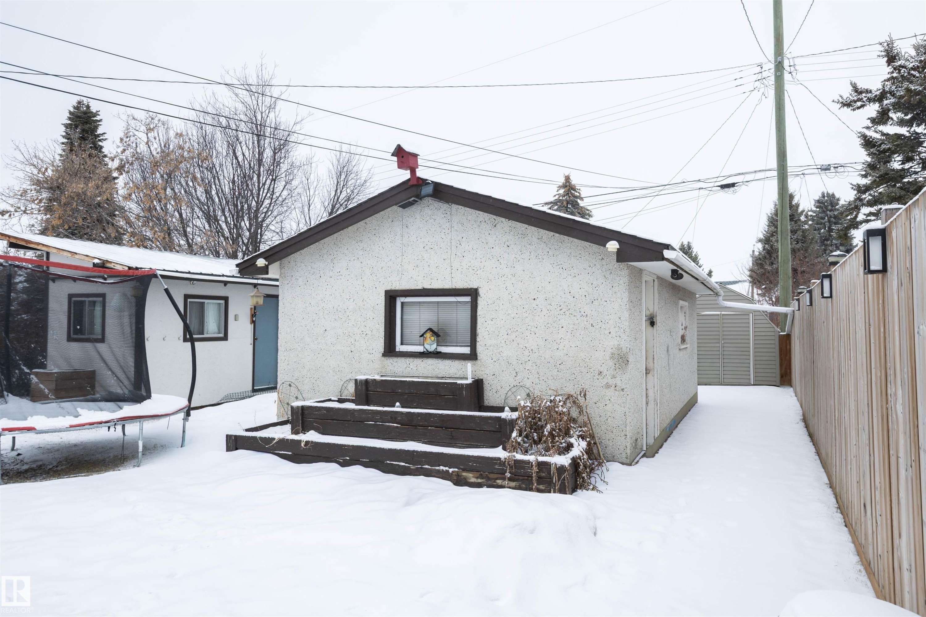 The property includes a detached structure with a pitched roof, a window, and a small wooden deck - 4420 56 Avenue, Barrhead, AB - Outdoor With Exterior