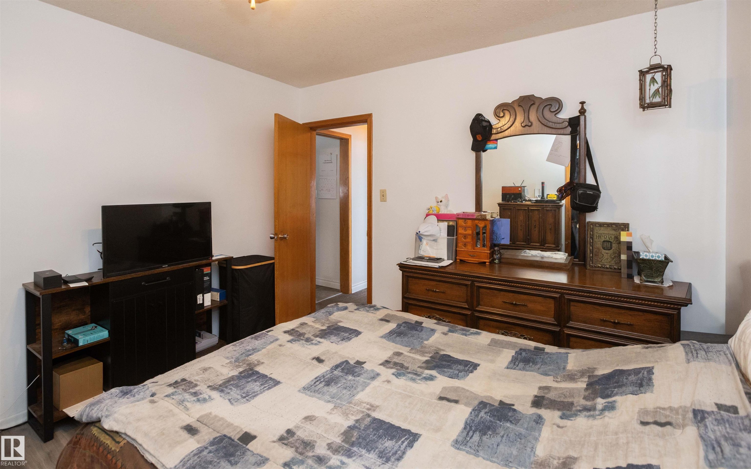 The bedroom features light-colored walls and a wooden door - 4420 56 Avenue, Barrhead, AB - Indoor Photo Showing Bedroom