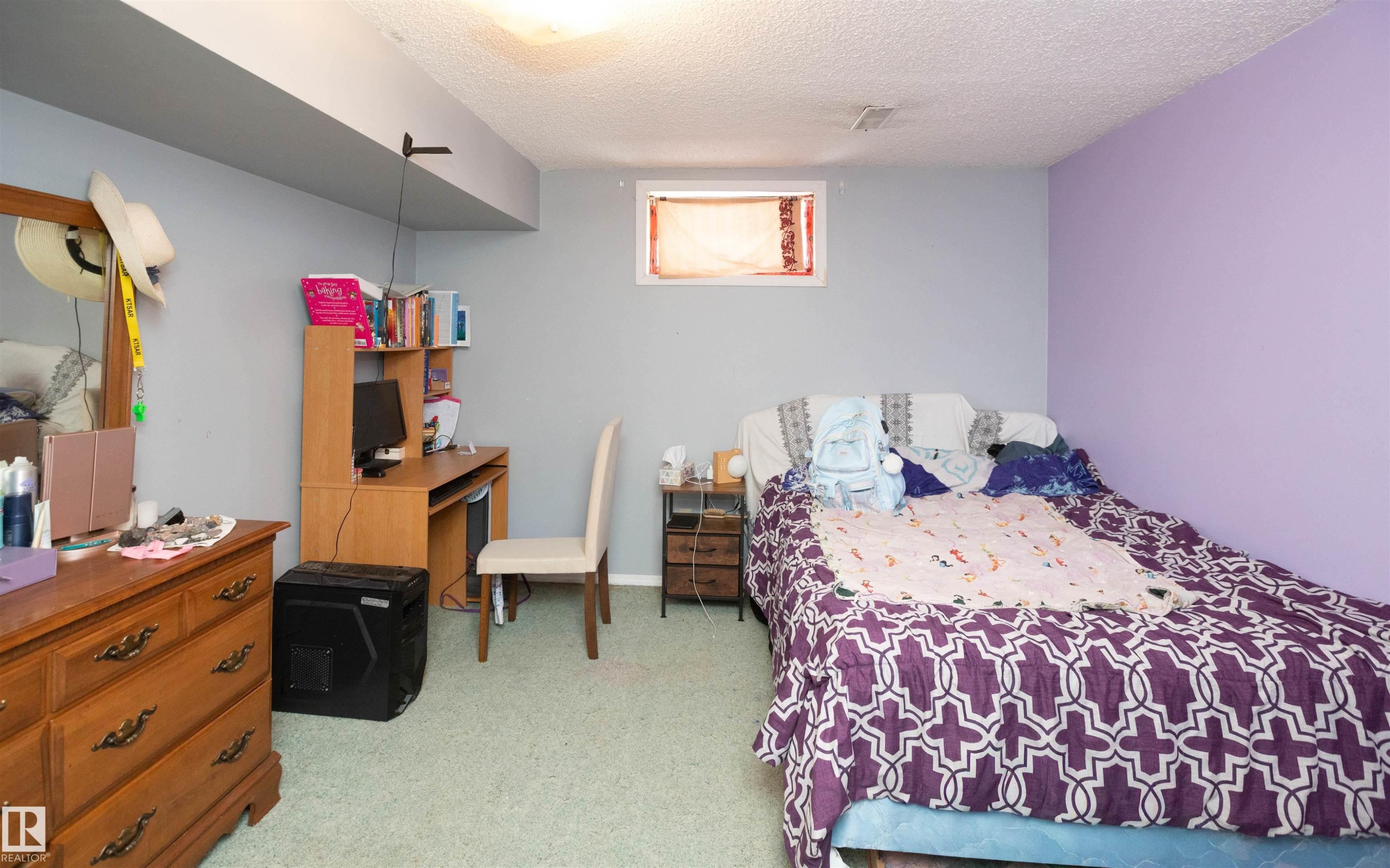 This room features light grey walls and a distinctive purple accent wall, providing a vibrant and versatile space - 4420 56 Avenue, Barrhead, AB - Indoor Photo Showing Bedroom