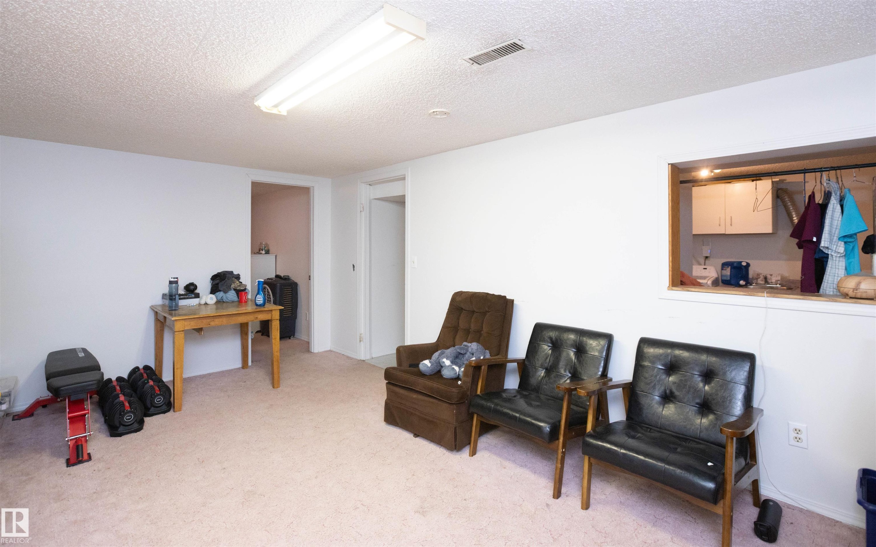 This spacious room features light-colored carpeting, white walls, and a recessed window opening - 4420 56 Avenue, Barrhead, AB - Indoor