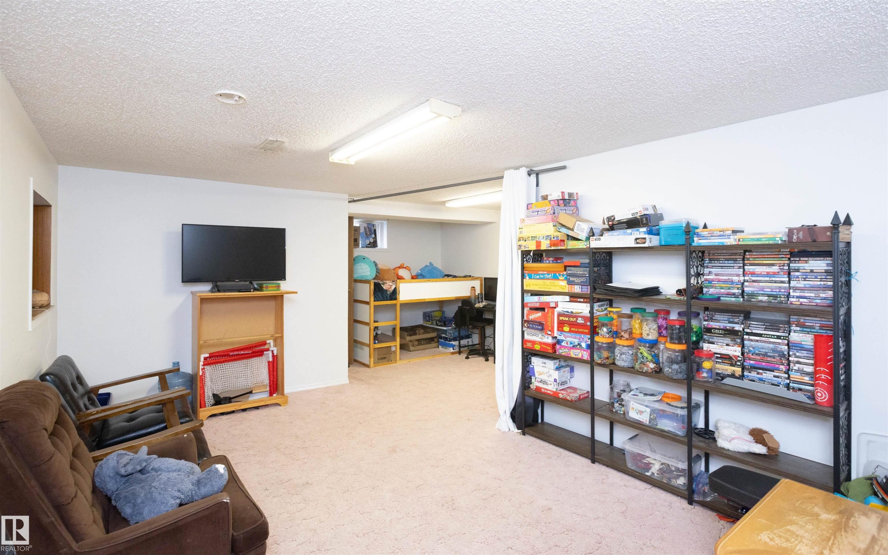Spacious room featuring carpeting, white walls, and overhead fluorescent lighting - 4420 56 Avenue, Barrhead, AB - Indoor