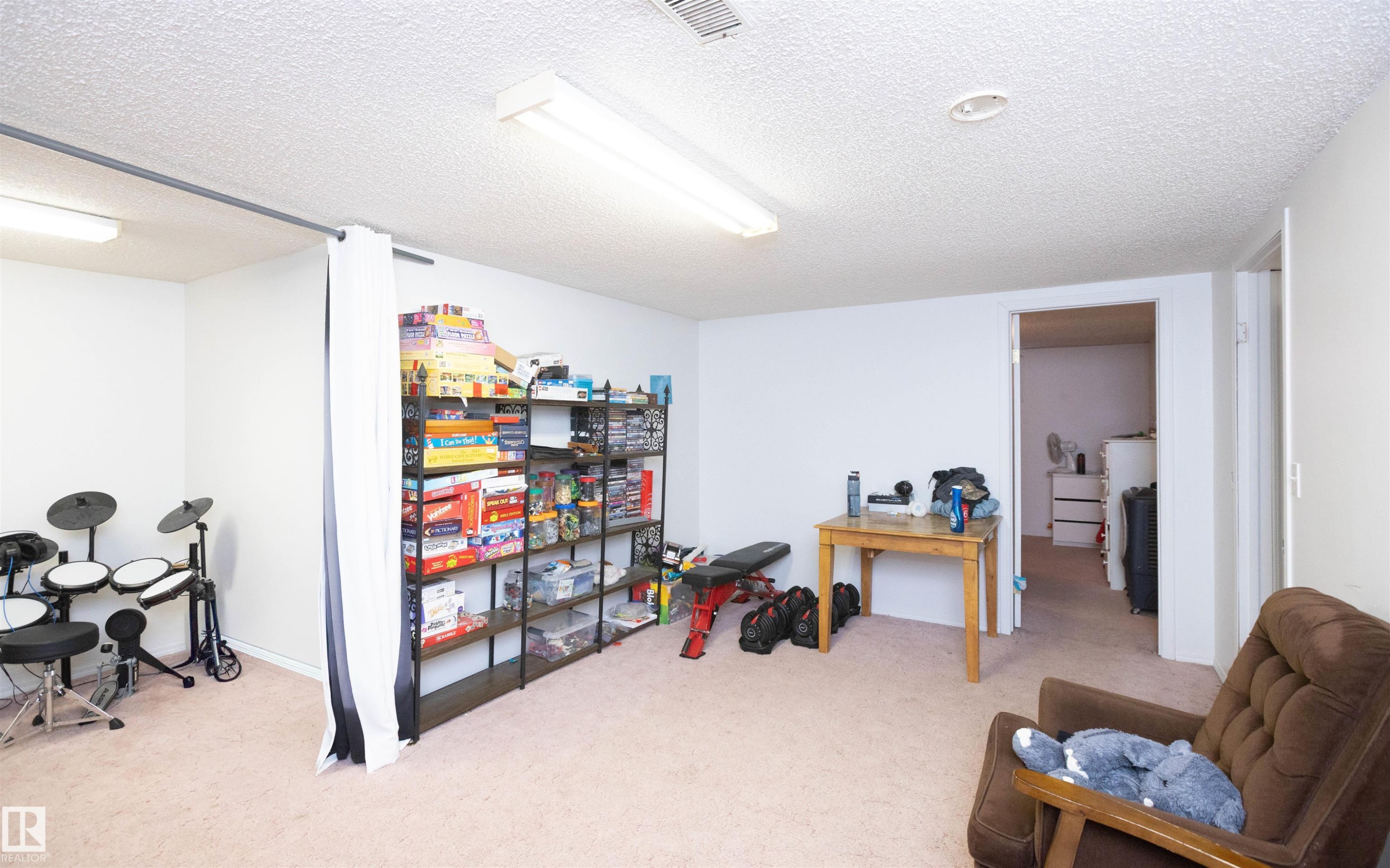 The room features light-colored carpeted flooring and white walls, creating a bright atmosphere - 4420 56 Avenue, Barrhead, AB - Indoor