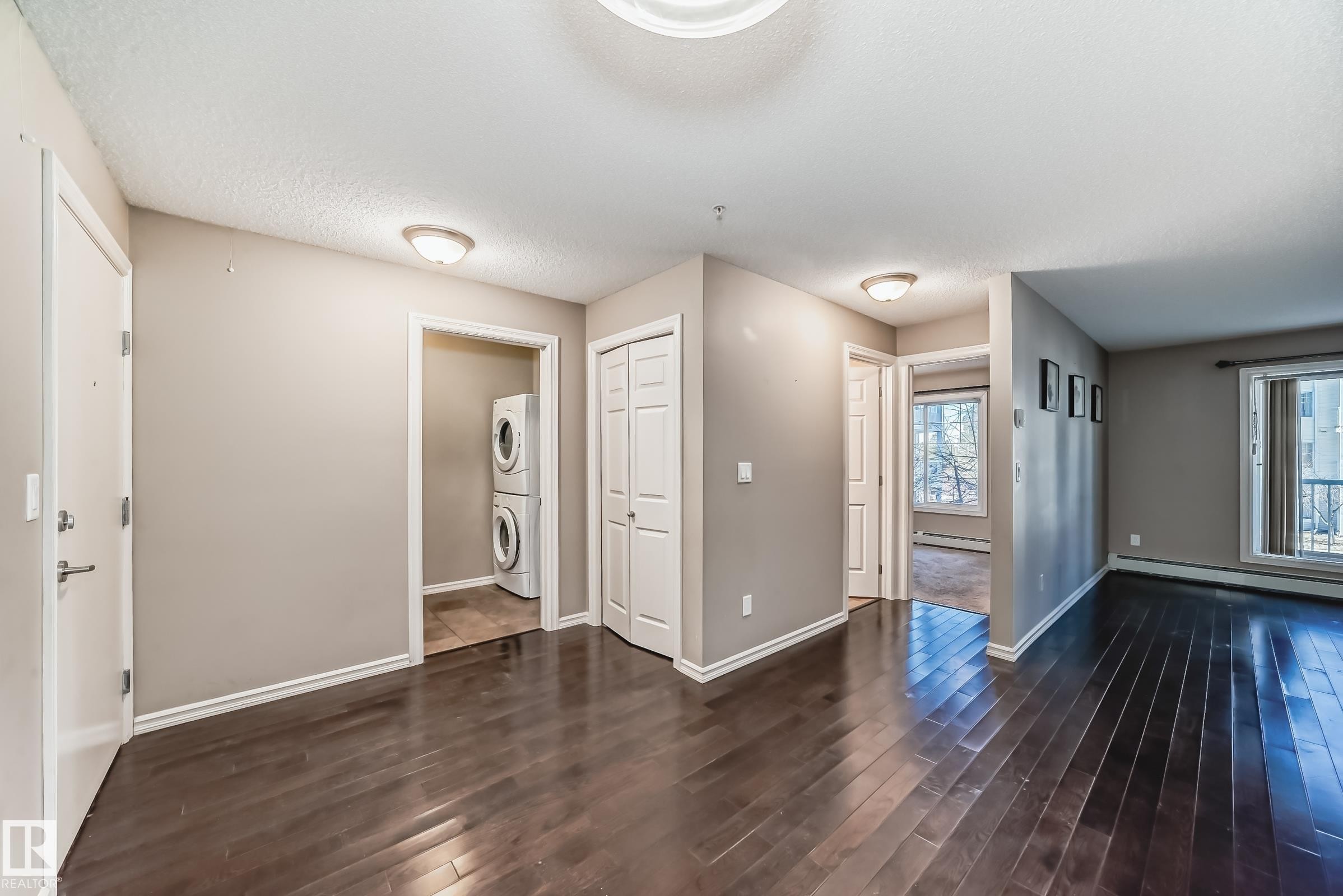 This inviting space features rich, dark hardwood flooring and light neutral walls - 208 2204 44 Ave, Edmonton, AB - Indoor Photo Showing Other Room