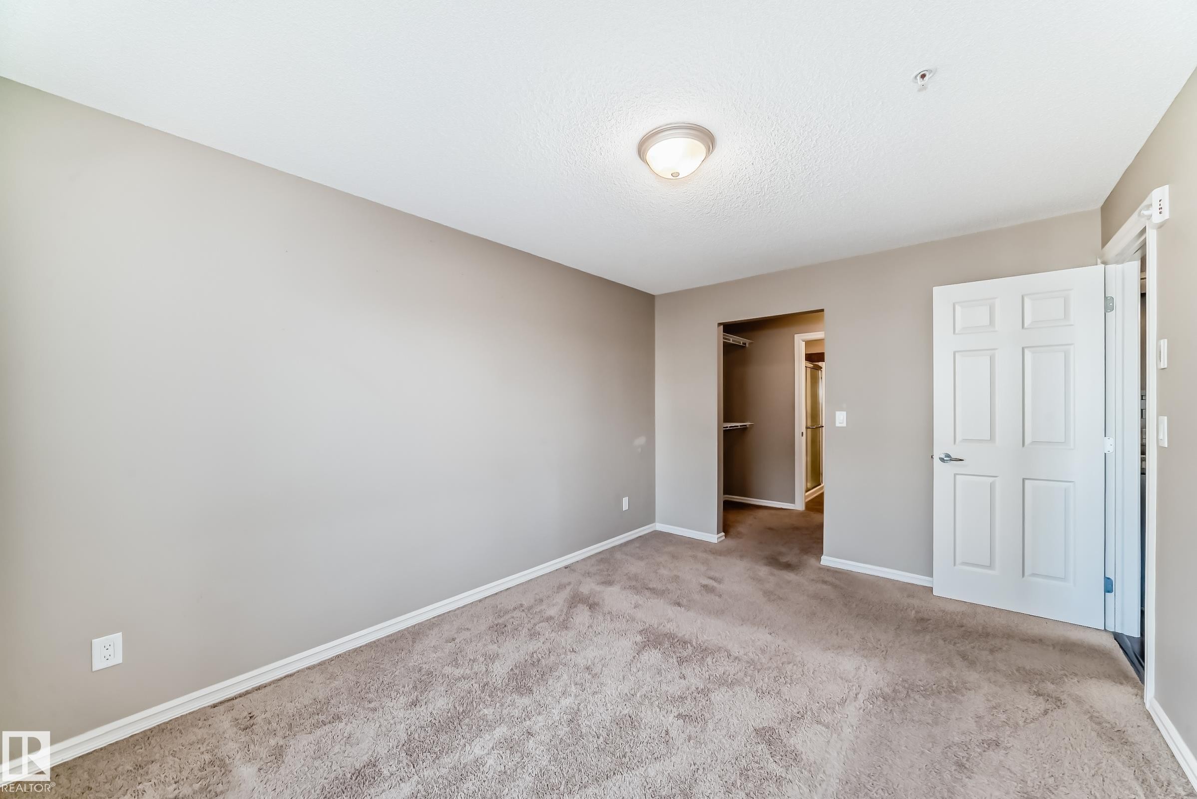 This space features carpeting and light-colored walls, offering a versatile canvas for personalization - 208 2204 44 Ave, Edmonton, AB - Indoor Photo Showing Other Room