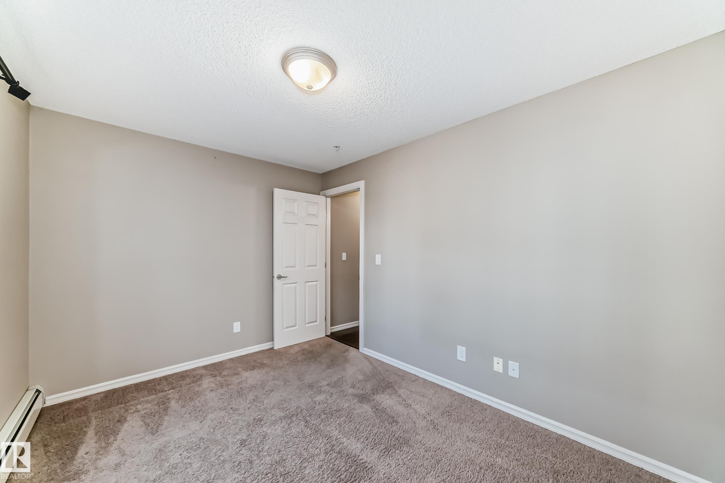 This room features carpeting, light neutral walls, and a white ceiling with a flush mount light fixture - 208 2204 44 Ave, Edmonton, AB - Indoor Photo Showing Other Room