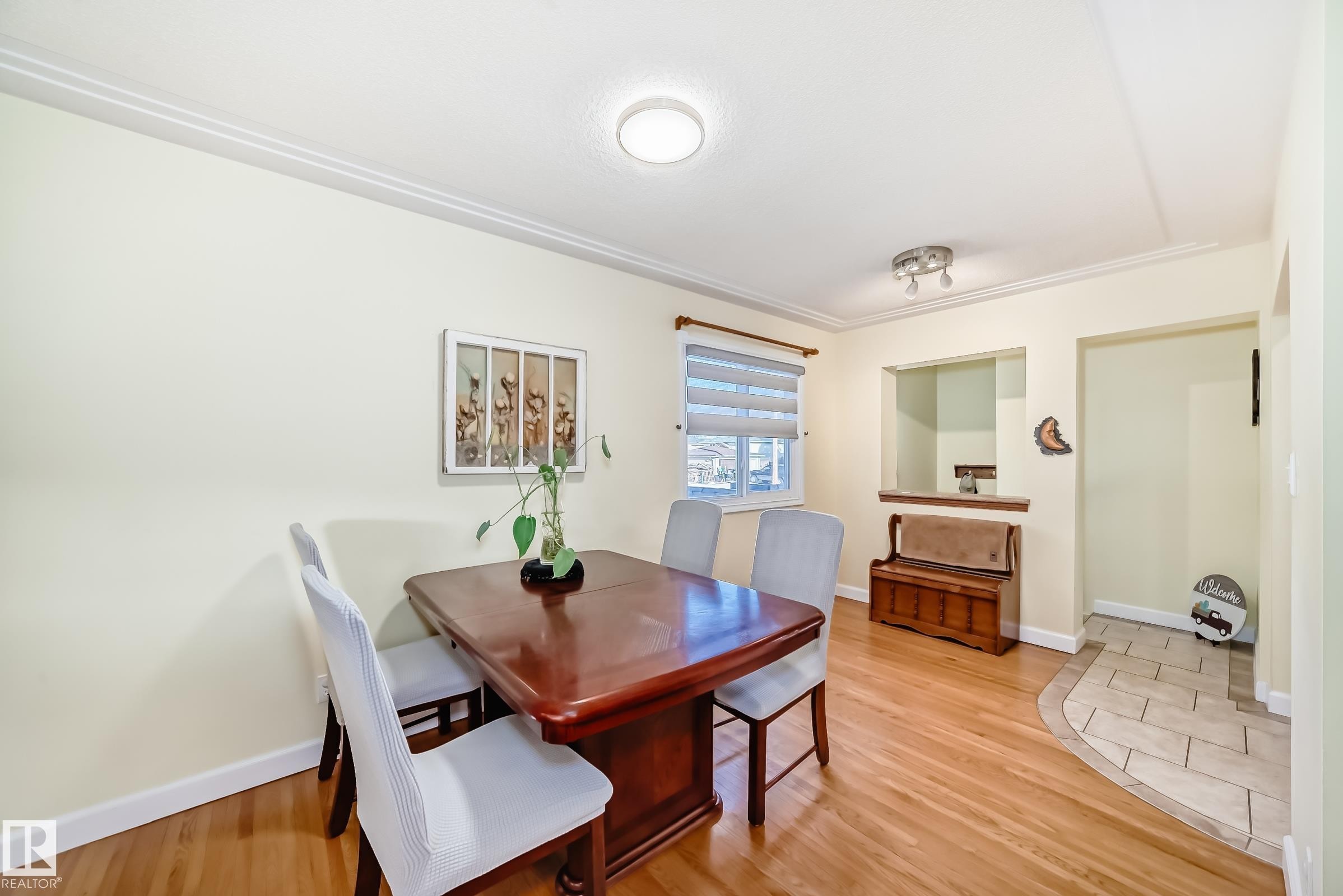This room features wood floors, light-colored walls, and crown molding - 4446 116 Avenue, Edmonton, AB - Indoor Photo Showing Dining Room