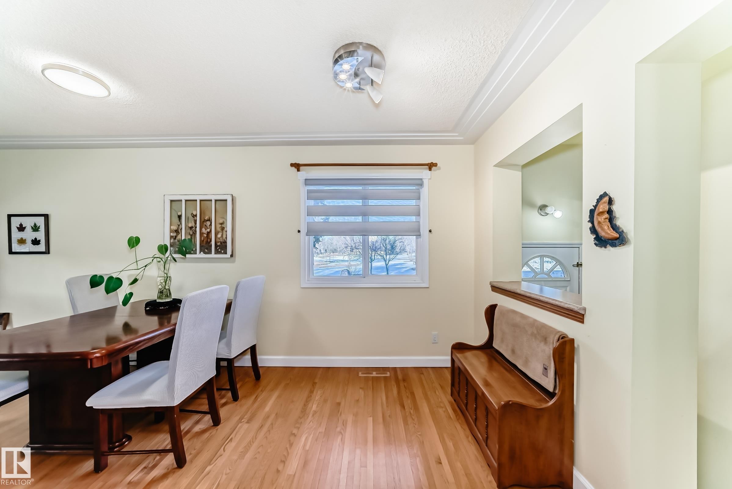 This bright room features hardwood floors, a window with blinds, and crown molding - 4446 116 Avenue, Edmonton, AB - Indoor