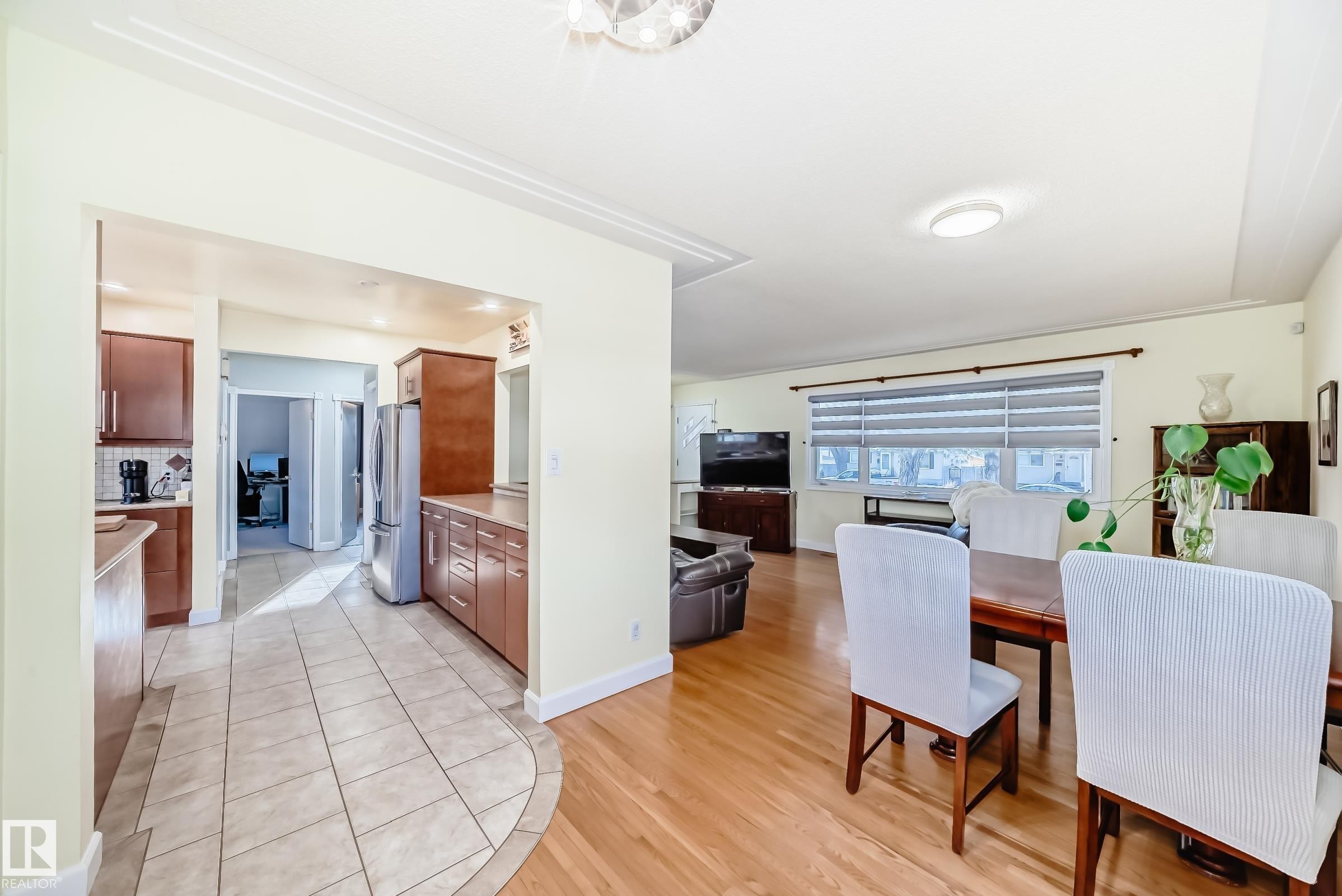 Open concept living and dining area featuring hardwood floors and a window with blinds - 4446 116 Avenue, Edmonton, AB - Indoor