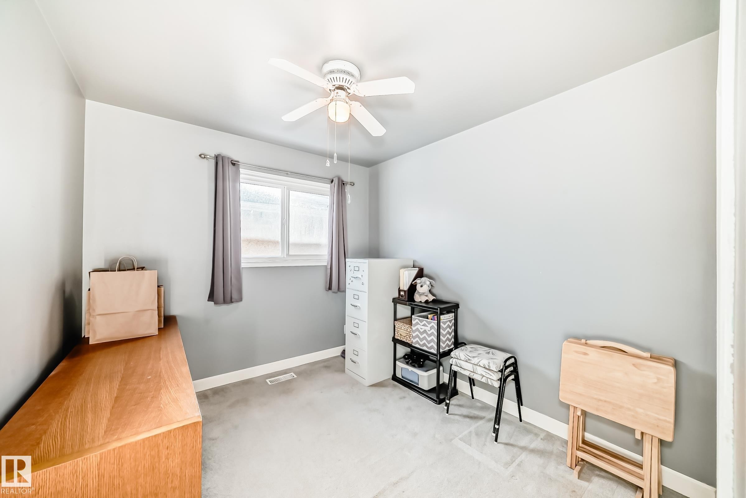 This room features light grey walls, a window with grey curtains, and a ceiling fan - 4446 116 Avenue, Edmonton, AB - Indoor