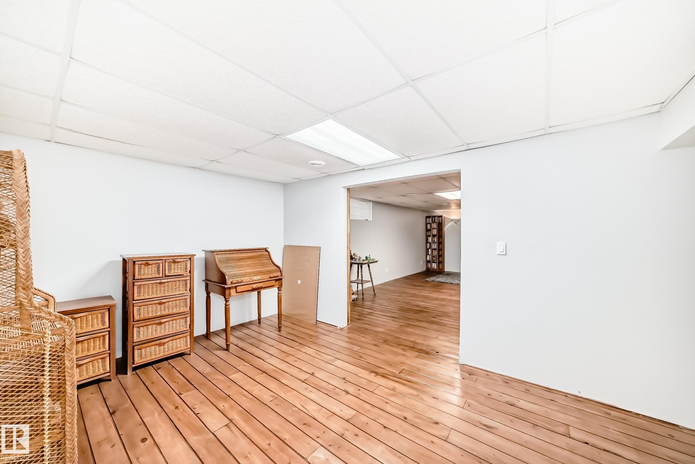 Spacious room with light-toned wood flooring and white walls, offering an open concept layout - 4446 116 Avenue, Edmonton, AB - Indoor Photo Showing Other Room