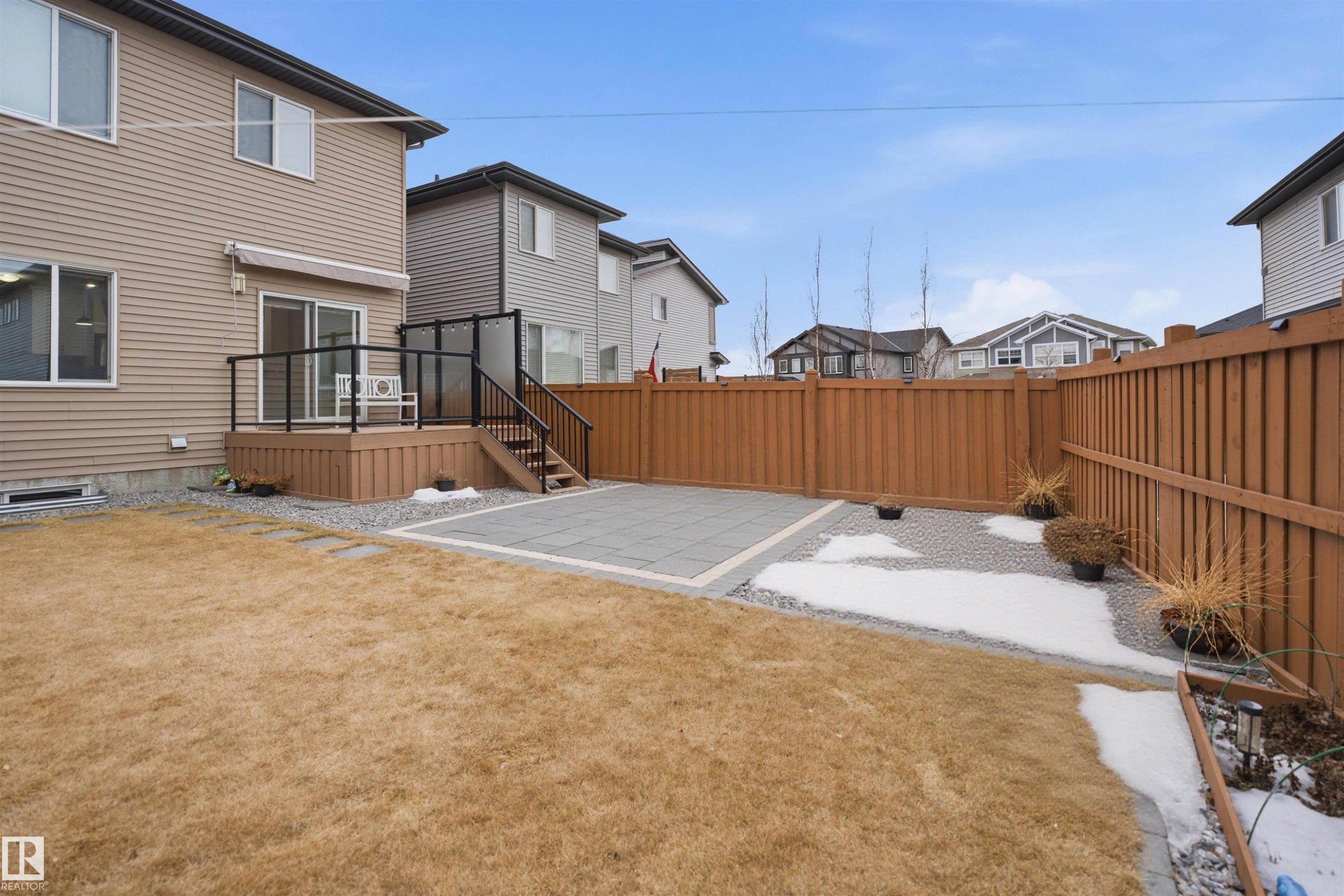The property features a fenced yard with a wooden deck, a paved patio area, and a lawn - 8424 Cushing Court, Edmonton, AB - Outdoor With Deck Patio Veranda With Exterior