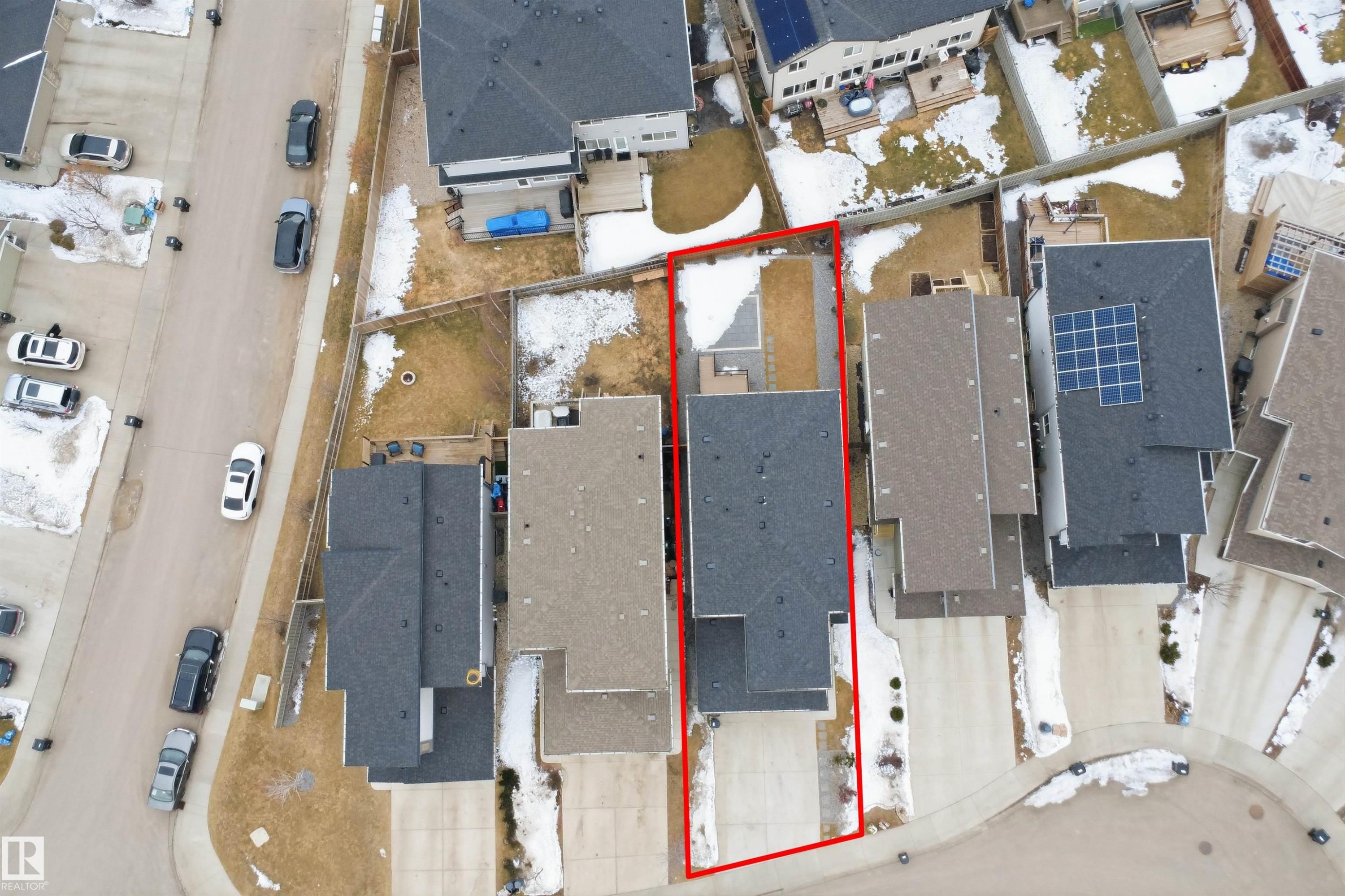 Aerial view of the property, featuring a paved driveway, a backyard with a patio area, and a dark-toned roof - 8424 Cushing Court, Edmonton, AB -