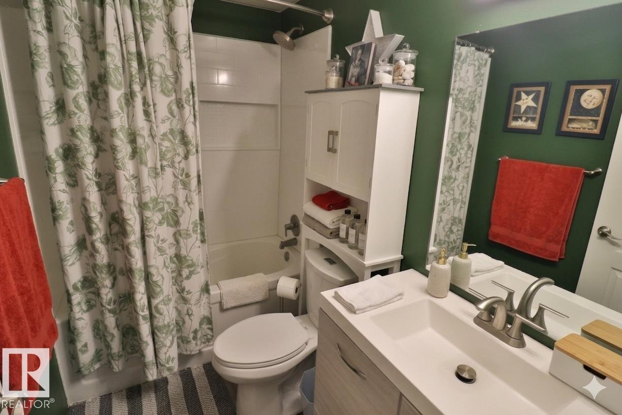 This bathroom features a vanity with a sink and a silver-toned faucet, a mirror, and a bathtub with a shower - 11 Willow Park Estates, Leduc, AB - Indoor Photo Showing Bathroom