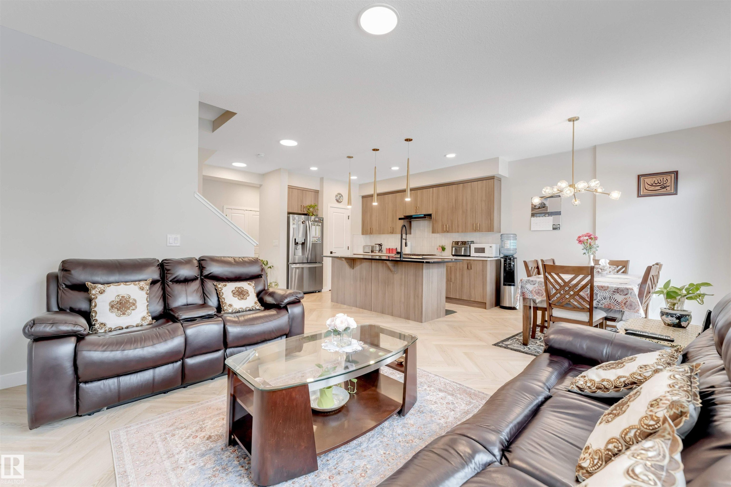 Open concept living area featuring a kitchen with an island, a dining area, and a staircase - 6404 27 Avenue, Edmonton, AB - Indoor Photo Showing Living Room