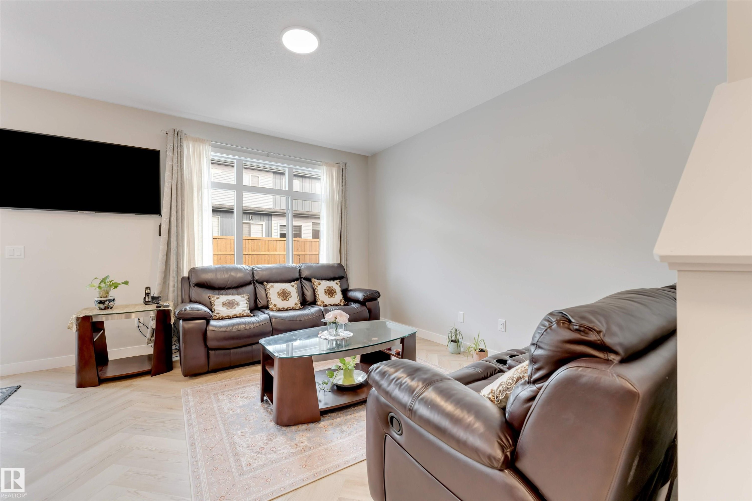This inviting living area features light-colored flooring, a large window, and neutral wall tones - 6404 27 Avenue, Edmonton, AB - Indoor Photo Showing Living Room