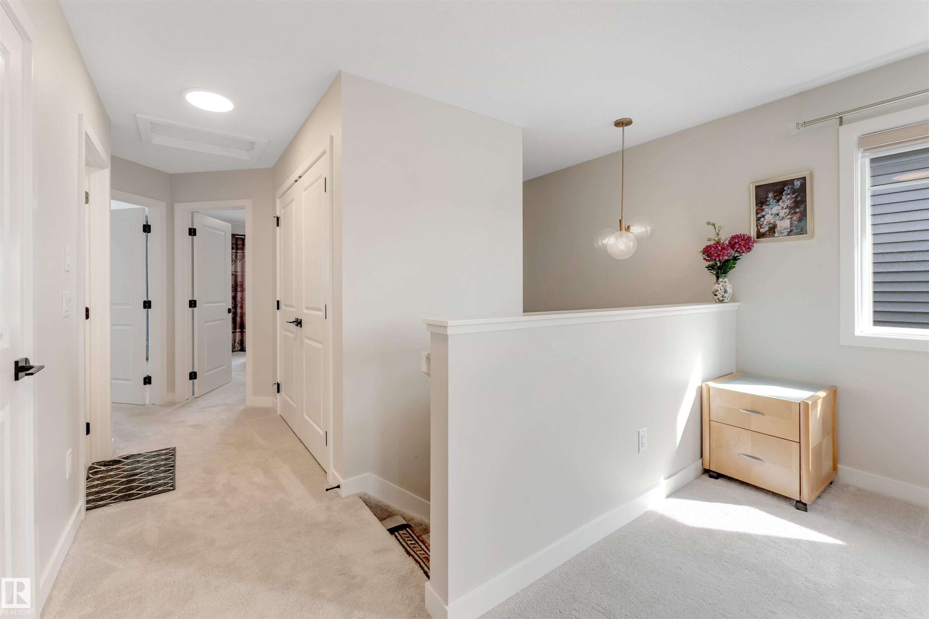 This property features carpeted hallways, white paneled doors with black hardware, and a round overhead light fixture - 6404 27 Avenue, Edmonton, AB - Indoor Photo Showing Other Room