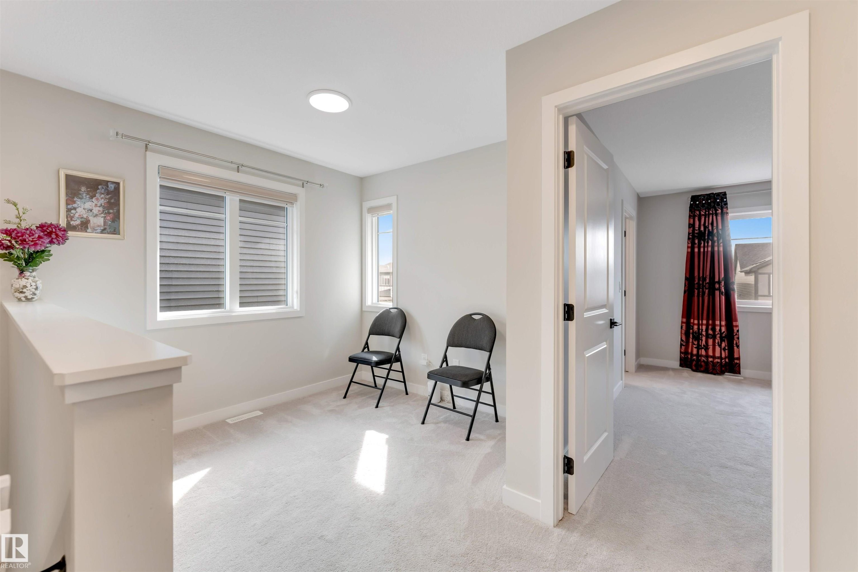 Carpeted landing area featuring multiple windows and a flush mount ceiling light - 6404 27 Avenue, Edmonton, AB - Indoor Photo Showing Other Room