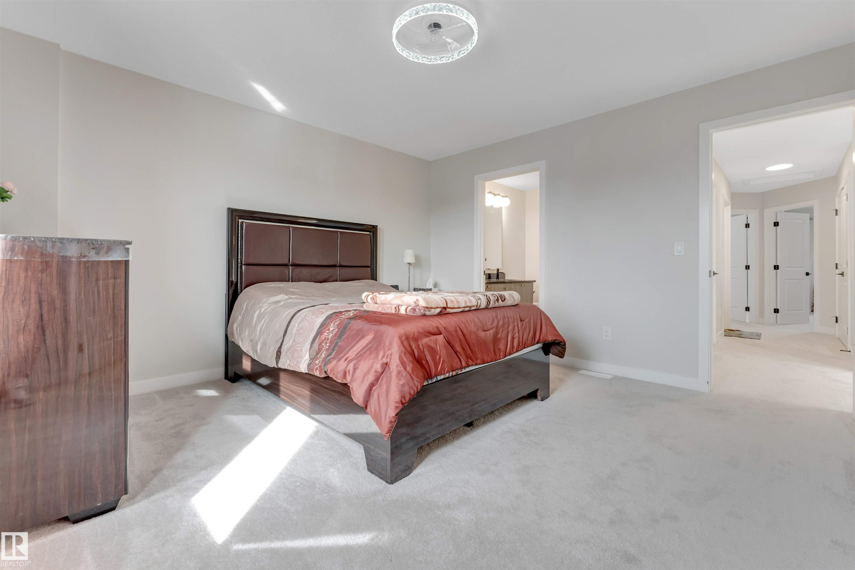 This room features light-colored carpeting, neutral painted walls, and a modern ceiling light fixture - 6404 27 Avenue, Edmonton, AB - Indoor Photo Showing Bedroom