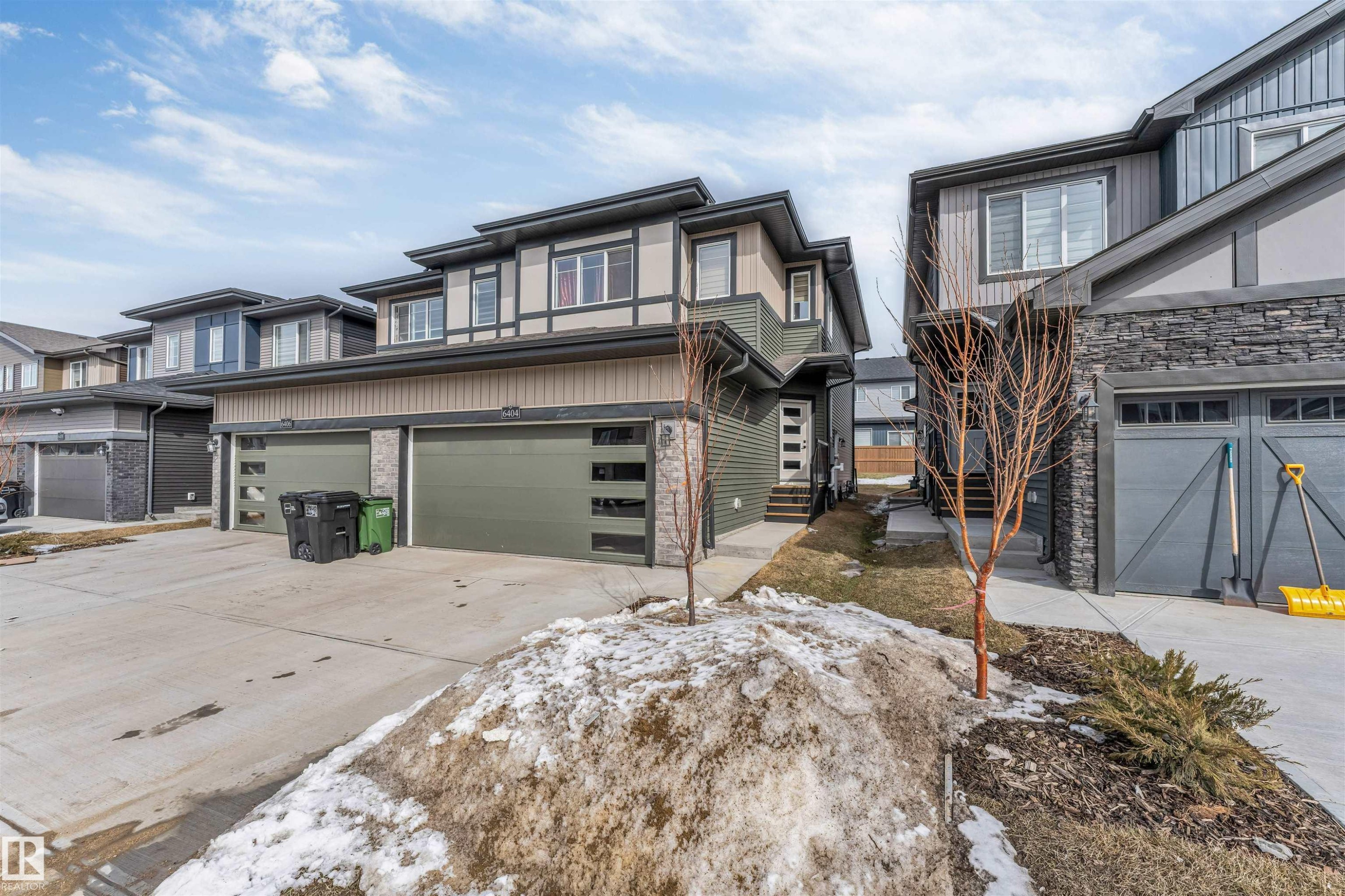 The property features a modern exterior with a grey and brown color palette, multiple windows, and an attached garage - 6404 27 Avenue, Edmonton, AB - Outdoor With Facade