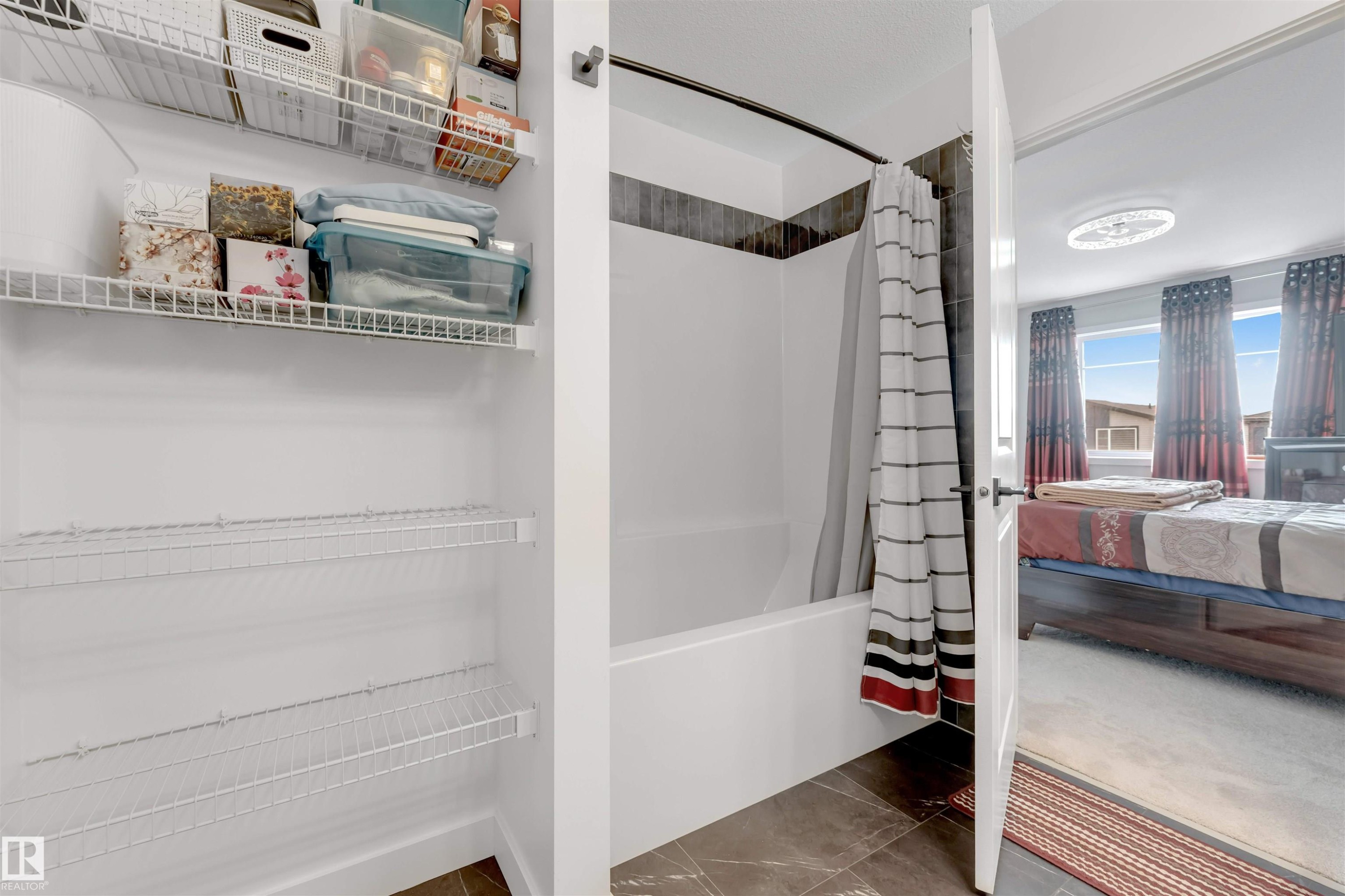 Bathroom featuring a combination bathtub and shower with tiled surround and a shower curtain - 6404 27 Avenue, Edmonton, AB - Indoor