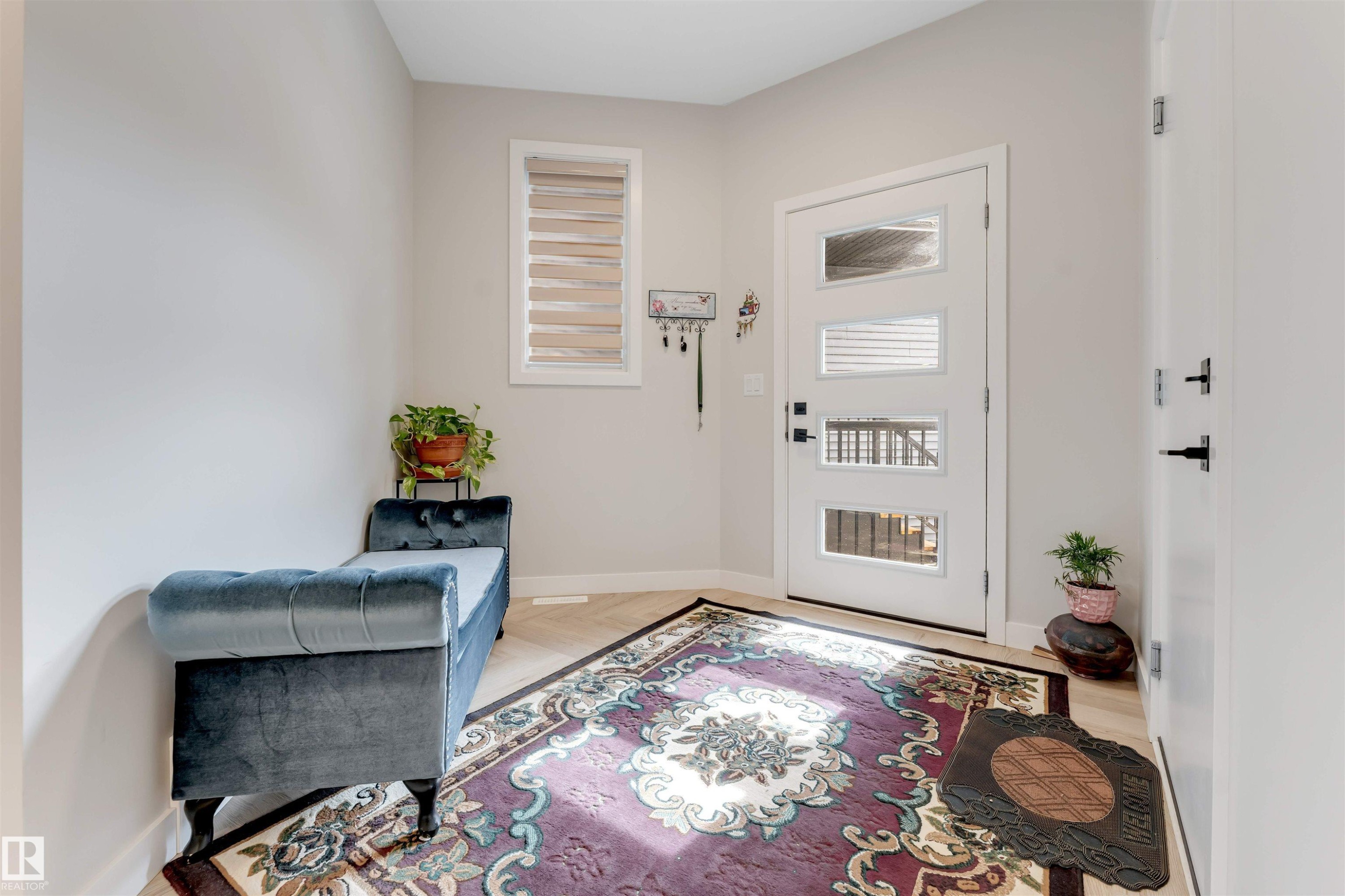The entry features light-toned flooring, a decorative rug, and a modern front door with frosted glass panels - 6404 27 Avenue, Edmonton, AB - Indoor Photo Showing Other Room