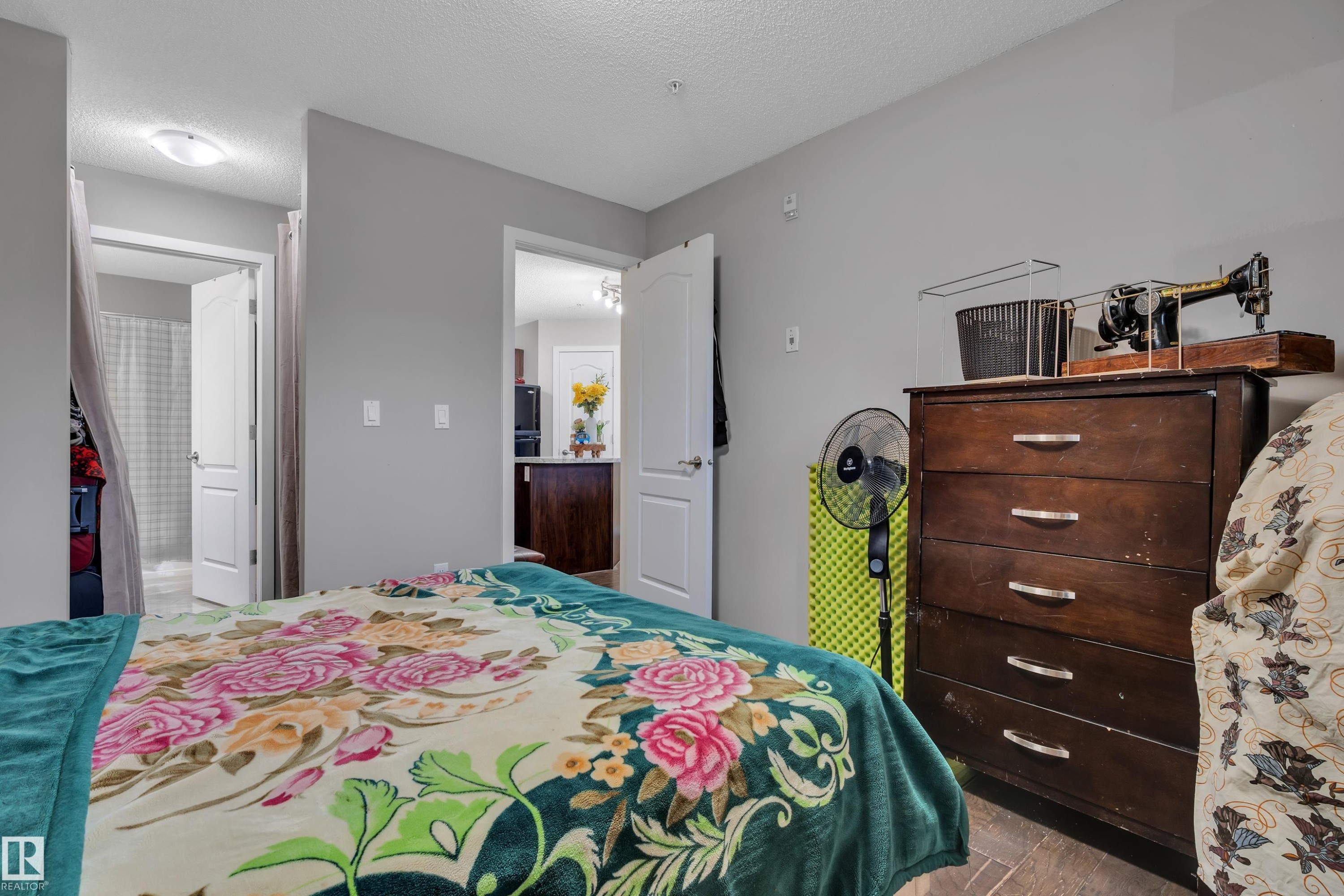 This bedroom features light gray walls and dark flooring - 320 392 Silver Berry Road, Edmonton, AB - Indoor Photo Showing Bedroom