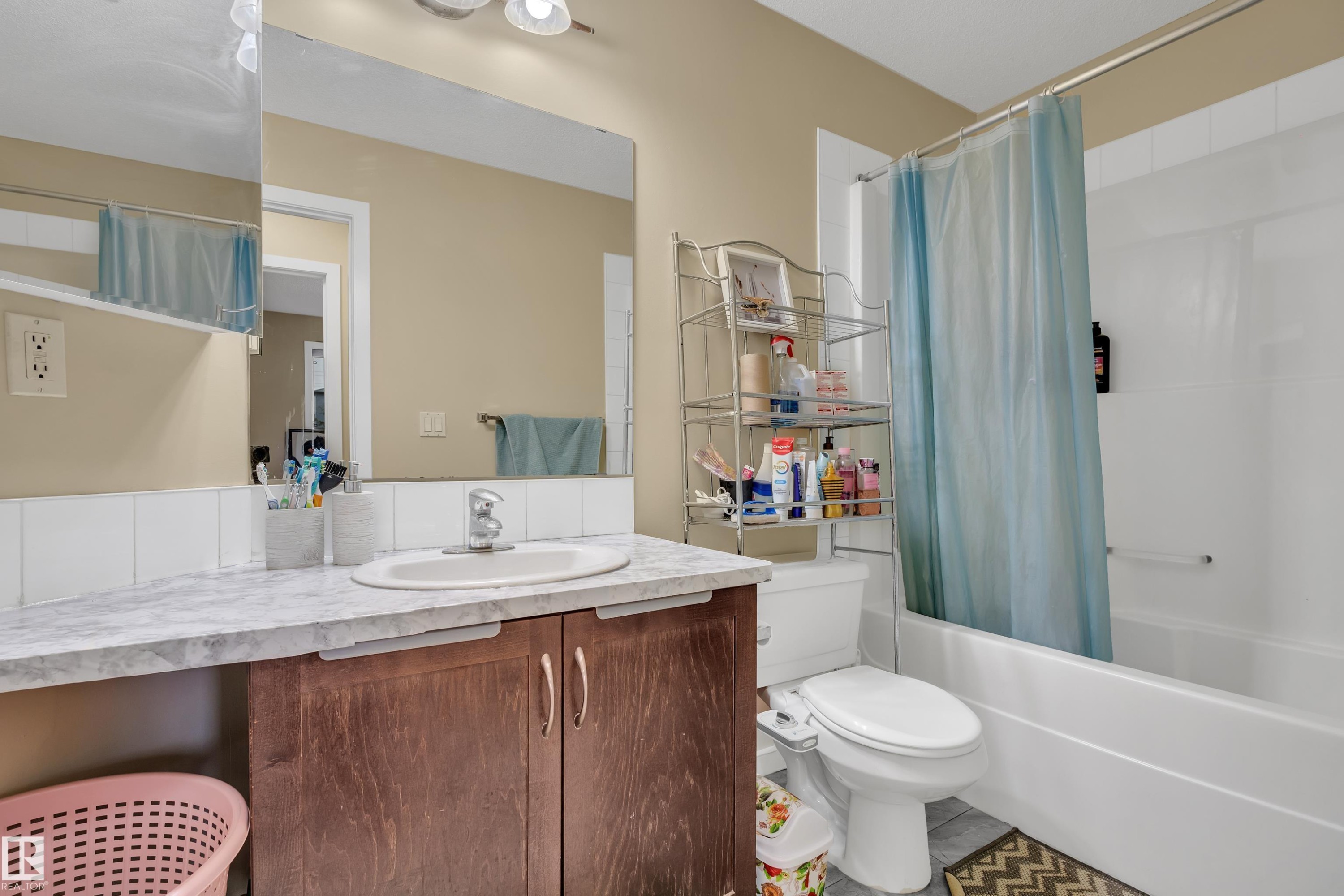 The bathroom features a vanity with a countertop and an integrated sink, a large mirror, and a combination shower and bathtub - 320 392 Silver Berry Road, Edmonton, AB - Indoor Photo Showing Bathroom