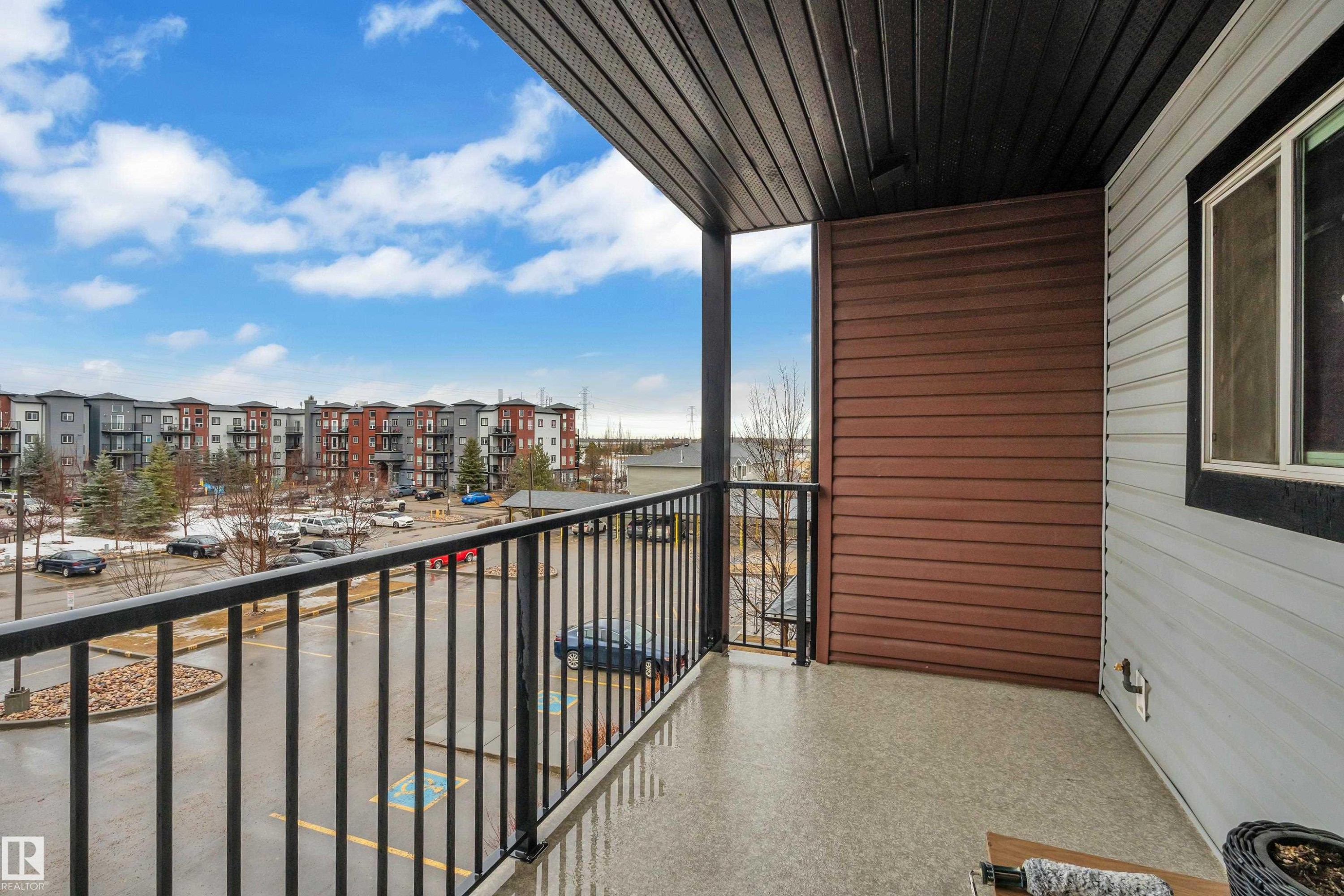The property features a private balcony with a view of the surrounding neighborhood and parking area - 320 392 Silver Berry Road, Edmonton, AB - Outdoor With Exterior