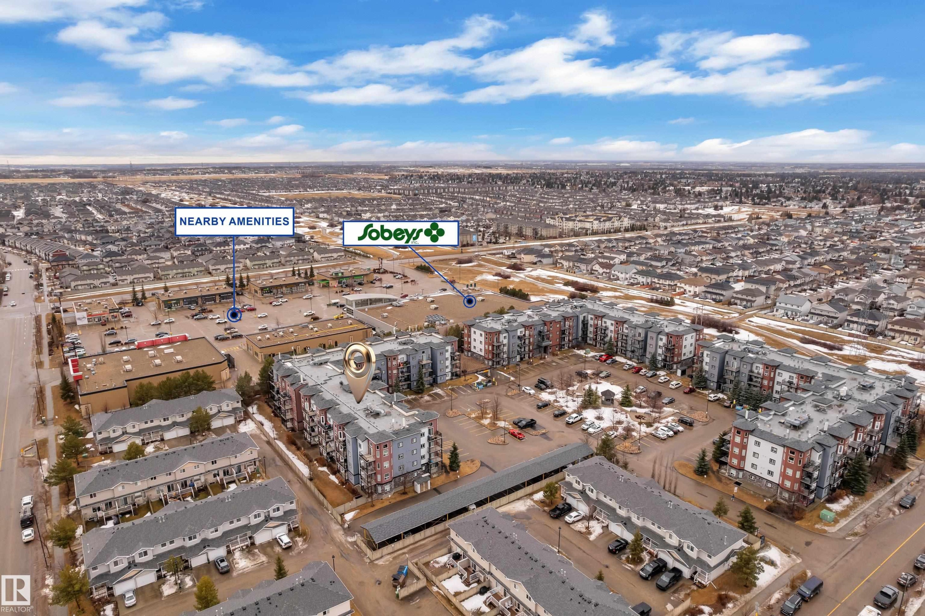 Aerial view of the property and surrounding neighborhood, featuring nearby retail amenities and residential buildings - 320 392 Silver Berry Road, Edmonton, AB - Outdoor With View