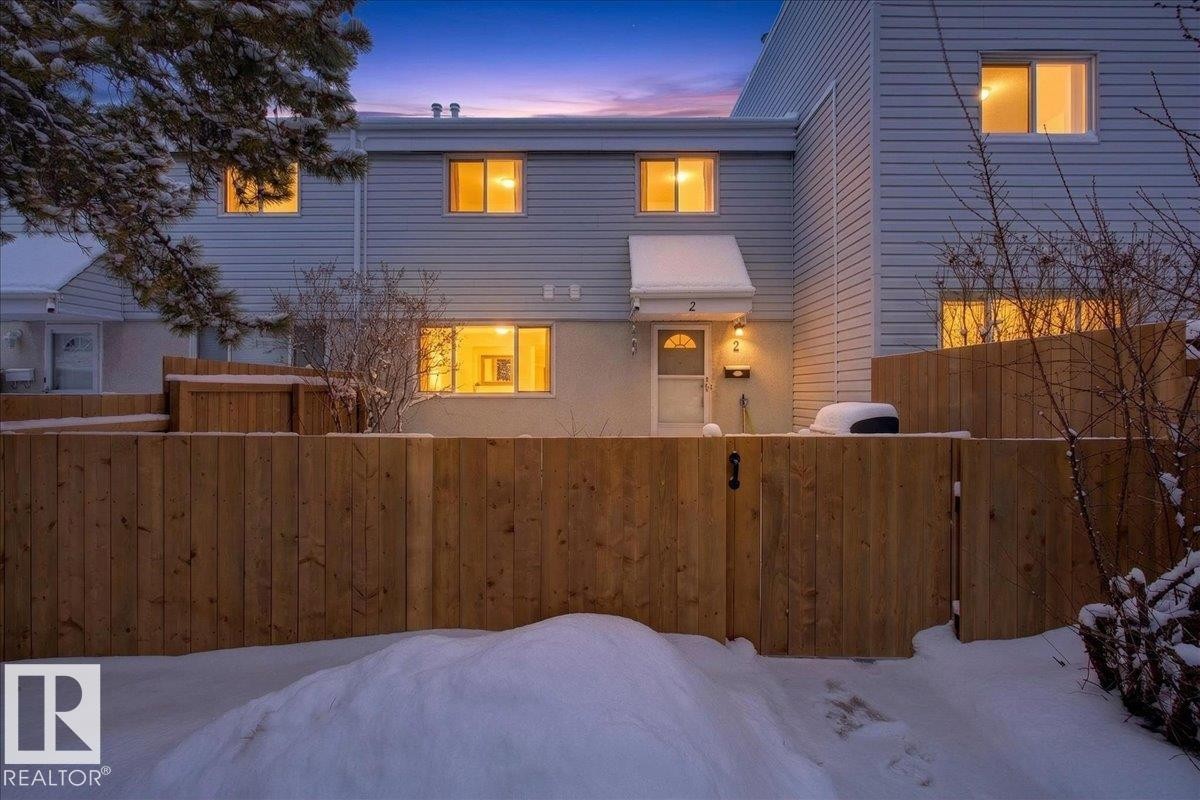 The property features light-colored horizontal siding and a prominent wooden fence - 2 Mcleod Place, Edmonton, AB - Outdoor With Exterior