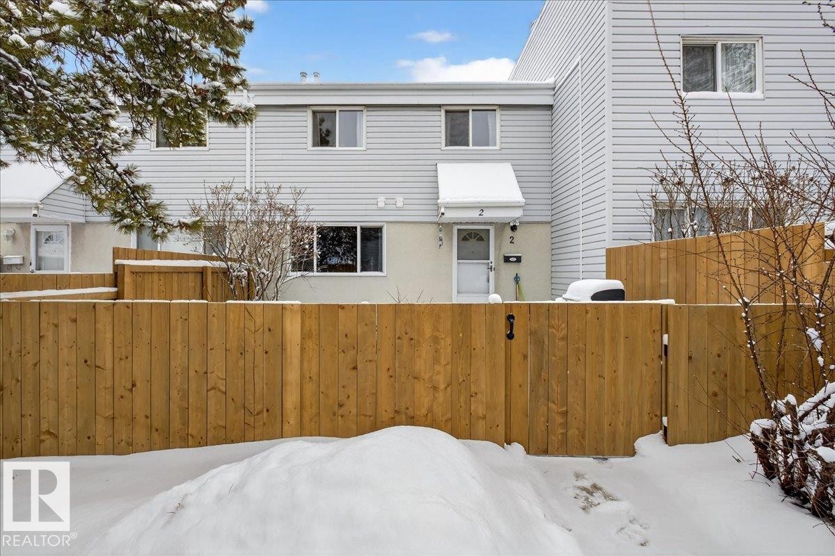 This property features a two-story exterior with light-colored siding and a contrasting fence - 2 Mcleod Place, Edmonton, AB - Outdoor