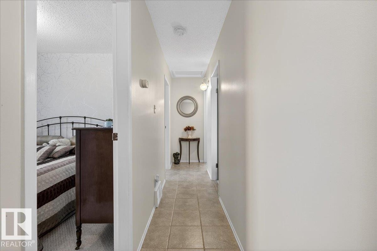 The interior features a hallway with light-colored walls and tiled flooring - 2 Mcleod Place, Edmonton, AB - Indoor Photo Showing Other Room