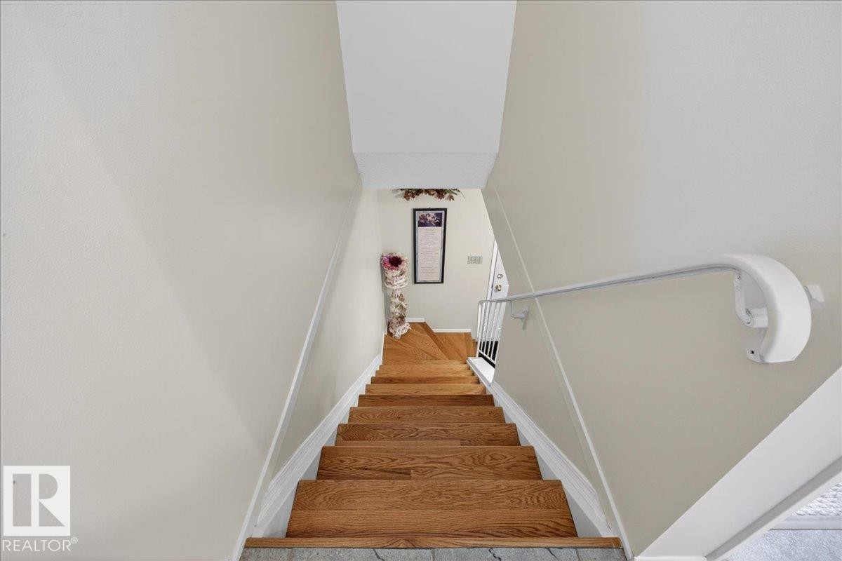 Staircase featuring hardwood steps and a white handrail, complemented by light-colored walls - 2 Mcleod Place, Edmonton, AB - Indoor Photo Showing Other Room