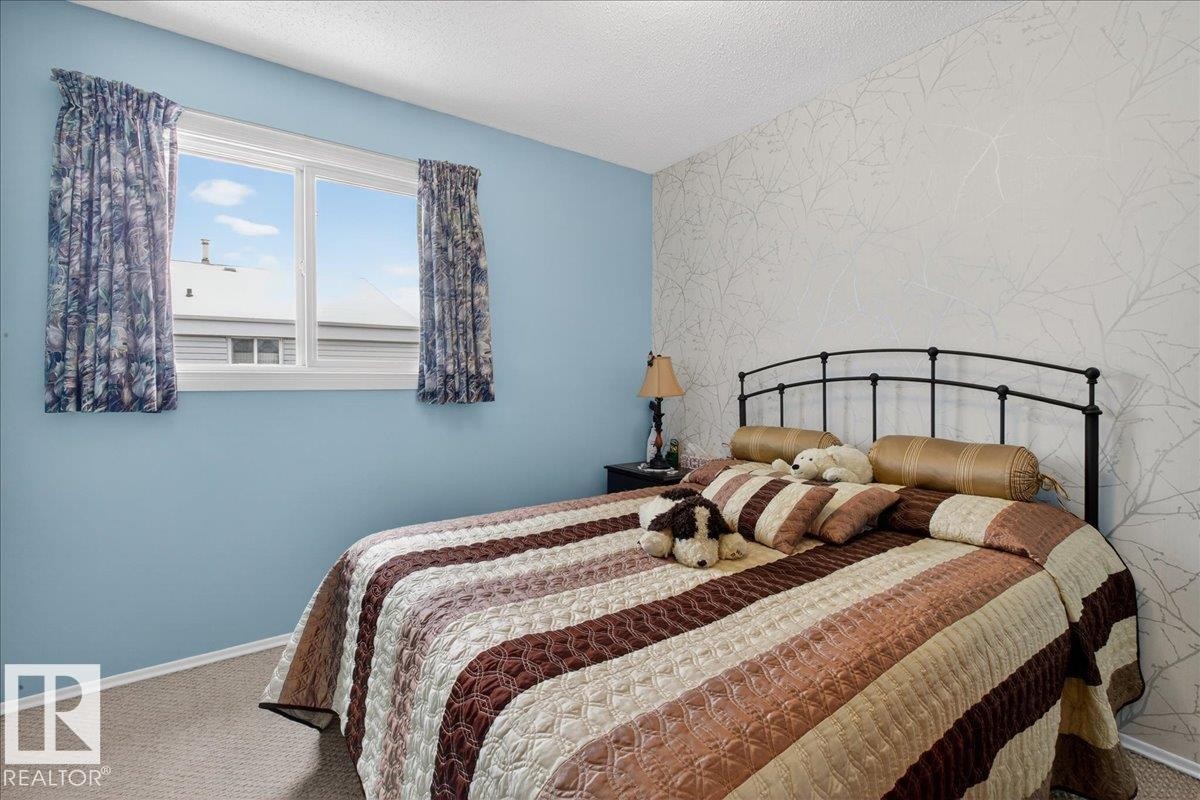 This room features a window providing natural light, carpeted flooring, and a decorative accent wall - 2 Mcleod Place, Edmonton, AB - Indoor Photo Showing Bedroom