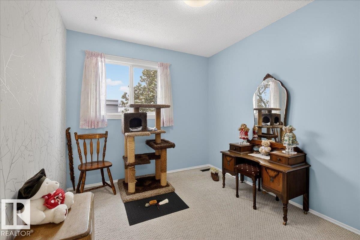 This room features a window providing natural light, light blue painted walls, and carpeting - 2 Mcleod Place, Edmonton, AB - Indoor