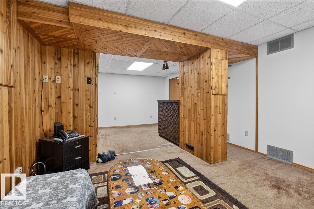 This room features wood paneling and a drop ceiling with recessed lighting - 2 Mcleod Place, Edmonton, AB - Indoor