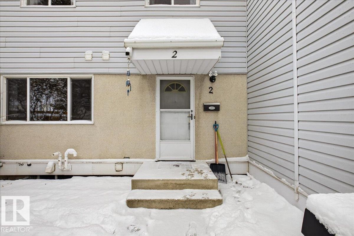 The property features light-colored horizontal siding and a contrasting textured lower wall - 2 Mcleod Place, Edmonton, AB - Outdoor With Exterior
