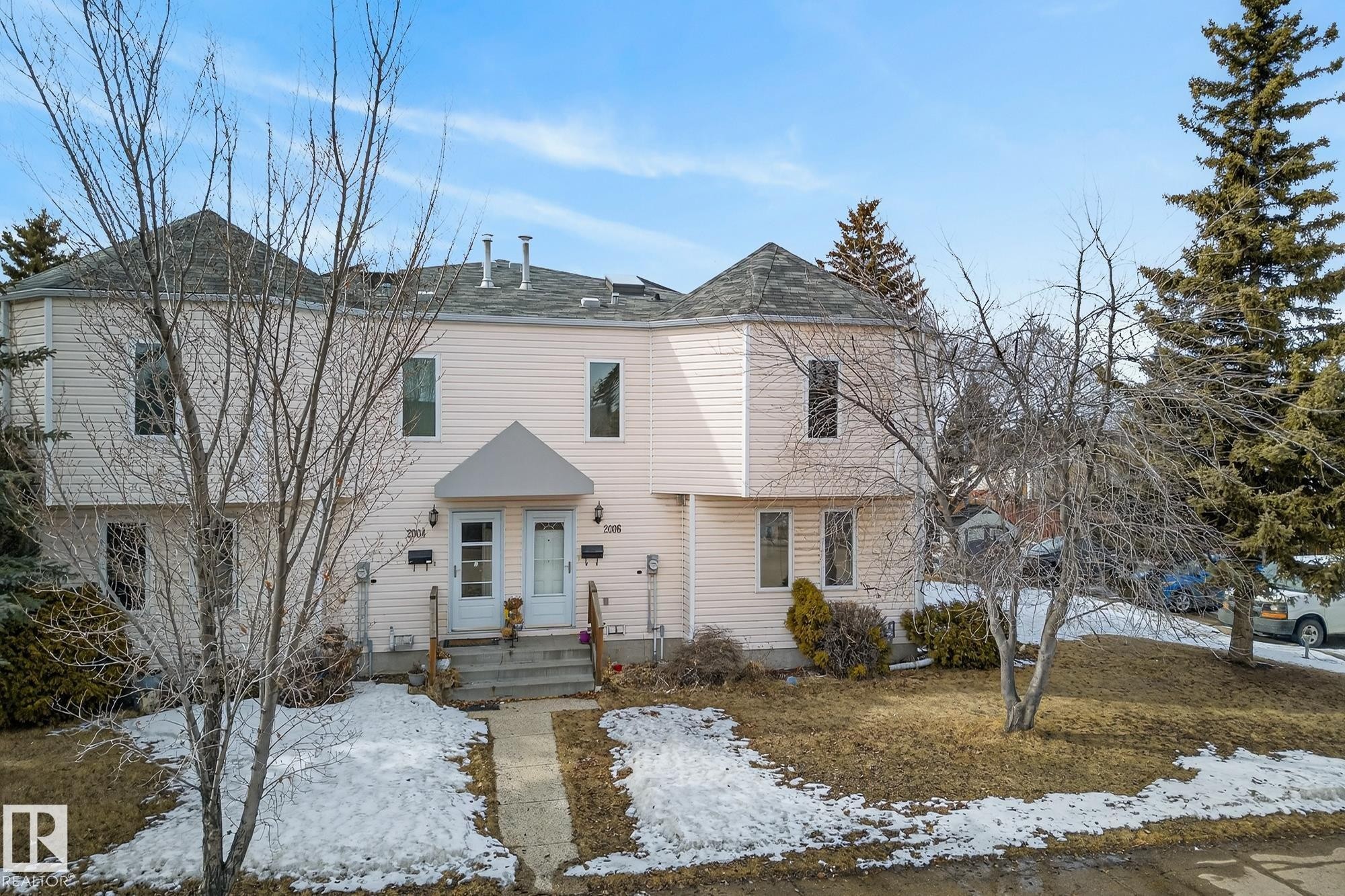 The property features light-colored siding and a grey shingled roof with visible vents - 2006 Mill Woods Road E, Edmonton, AB - Outdoor With Facade