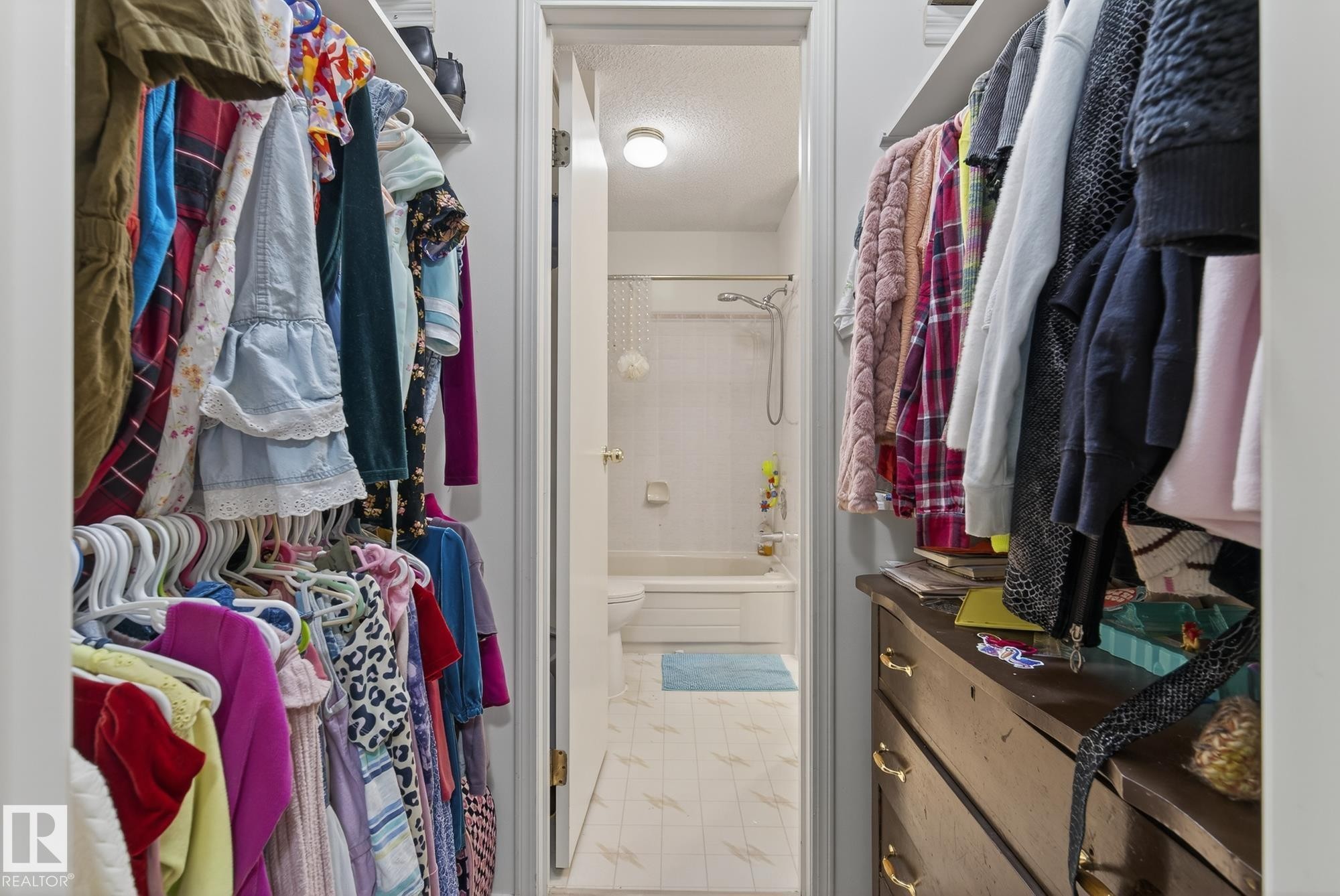 This photo features a walk-in closet with built-in shelving and hanging rods, providing ample storage space - 2006 Mill Woods Road E, Edmonton, AB - Indoor With Storage